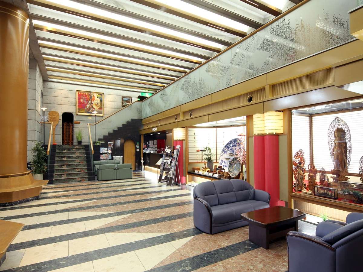 Spacious lobby lounge with marble floor, gold columns and seating at Miyajima Hotel Makoto