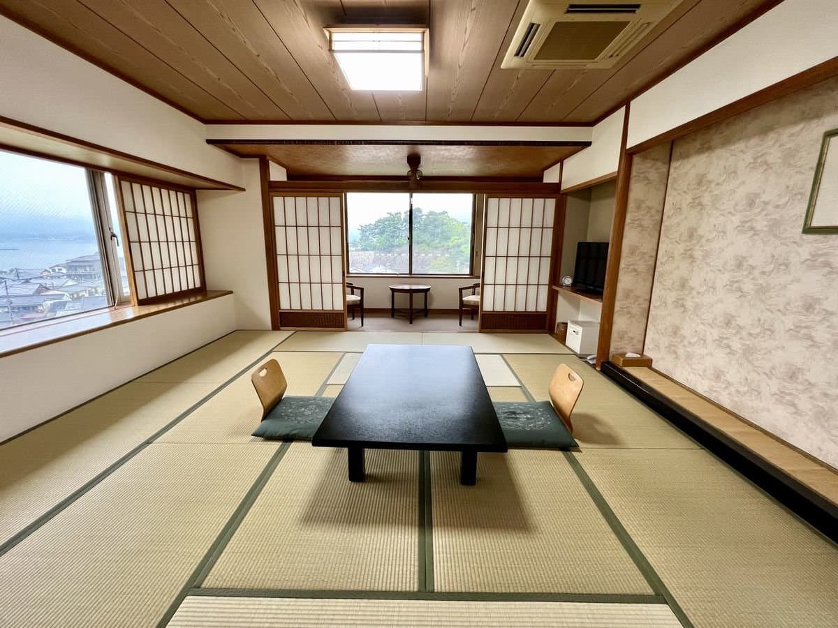 Tatami guest room with corner windows overlooking the Seto Inland Sea and Miyajima townscape