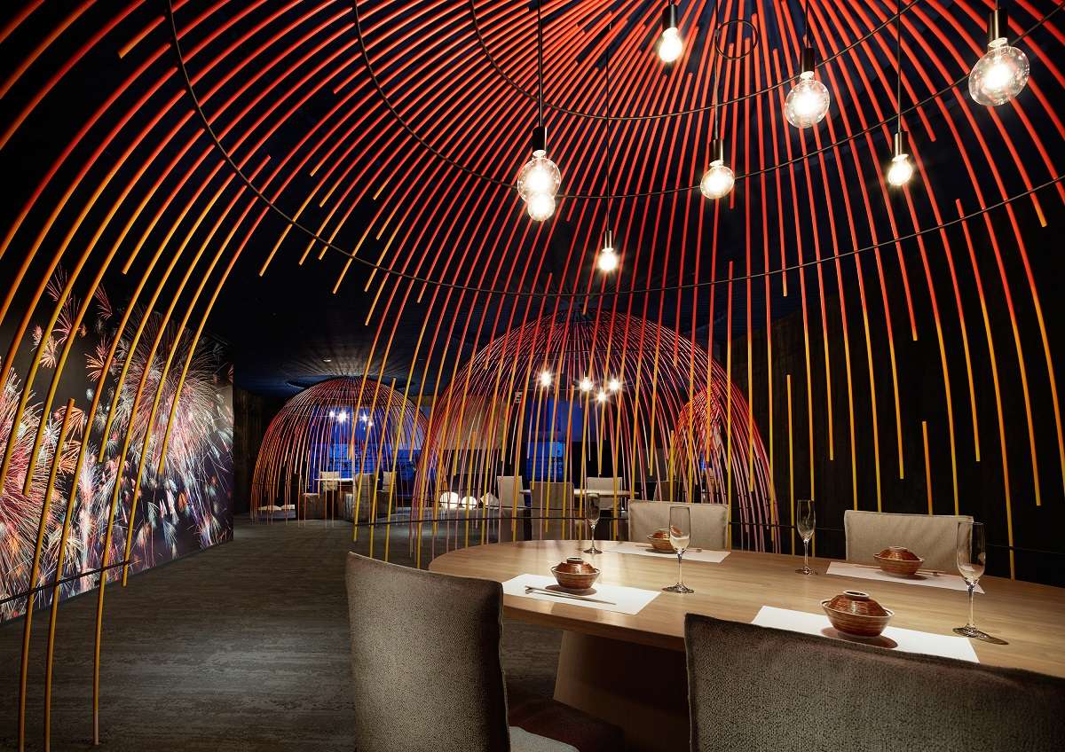 Firework-inspired dining hall at Risonare Atami with arched reed installations and set tables