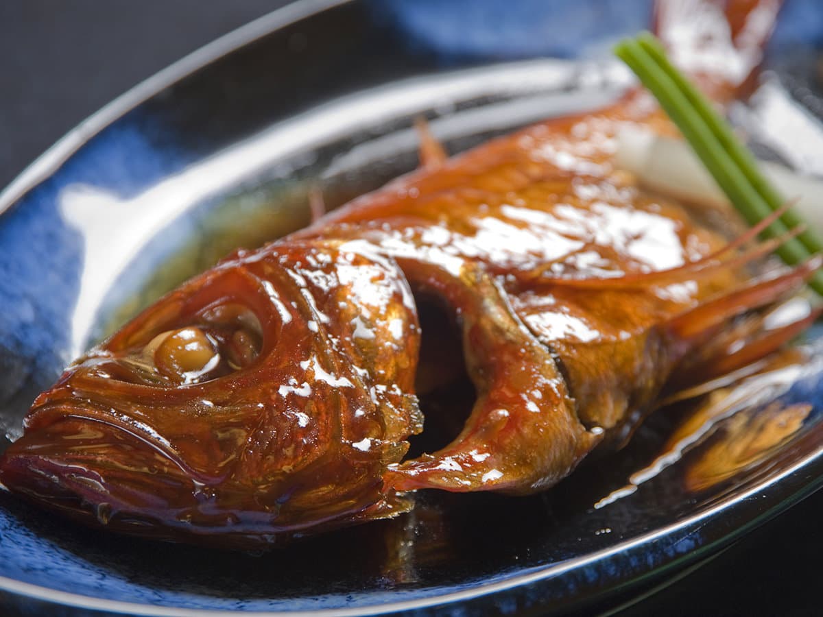 Whole simmered kinmedai golden-eye snapper, the Inatori specialty dish, plated at Hama no Yu
