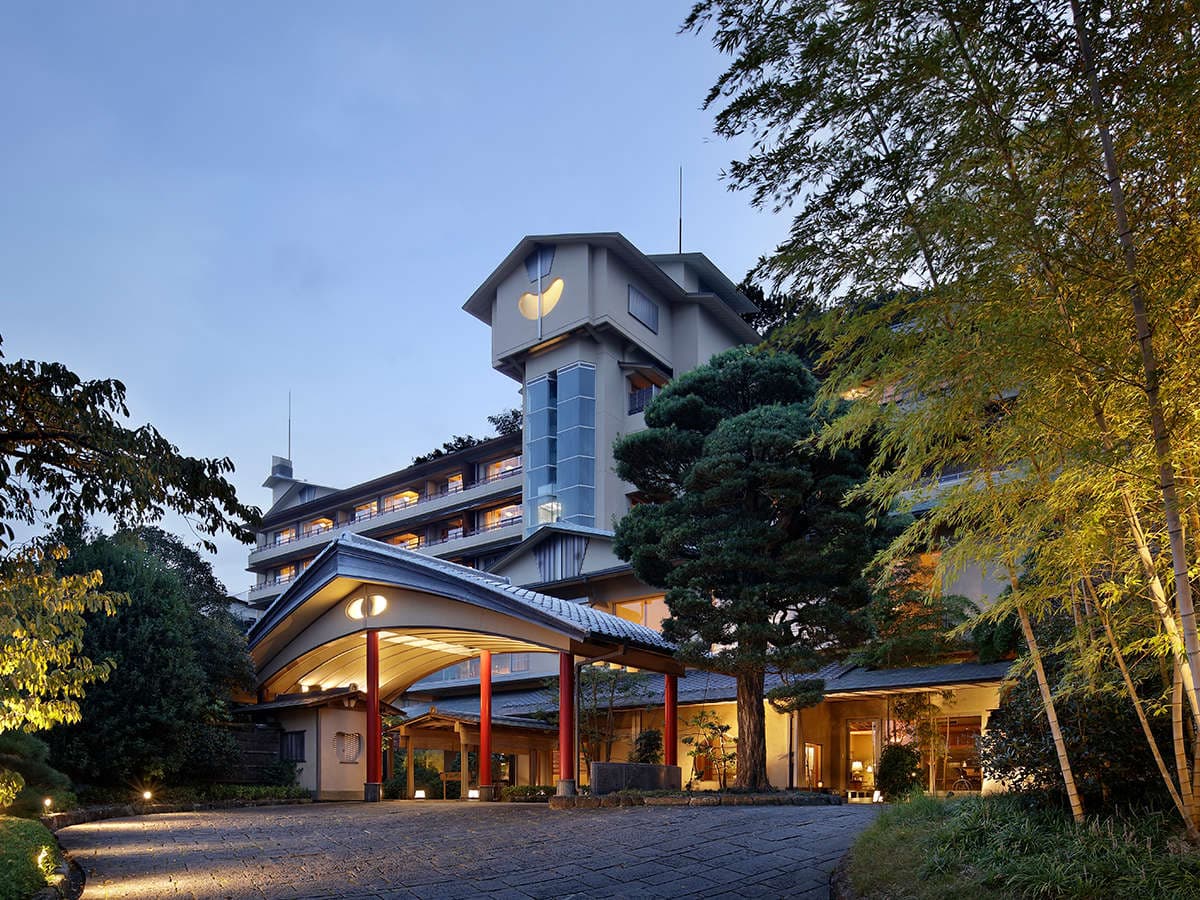 Seizan Yamato ryokan main building exterior lit at dusk among pines, Ito Onsen, Izu