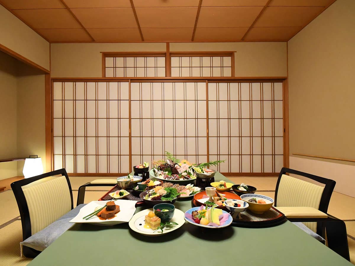 Multi-course kaiseki dinner spread set on a table in a tatami room at Seizan Yamato, Ito Onsen
