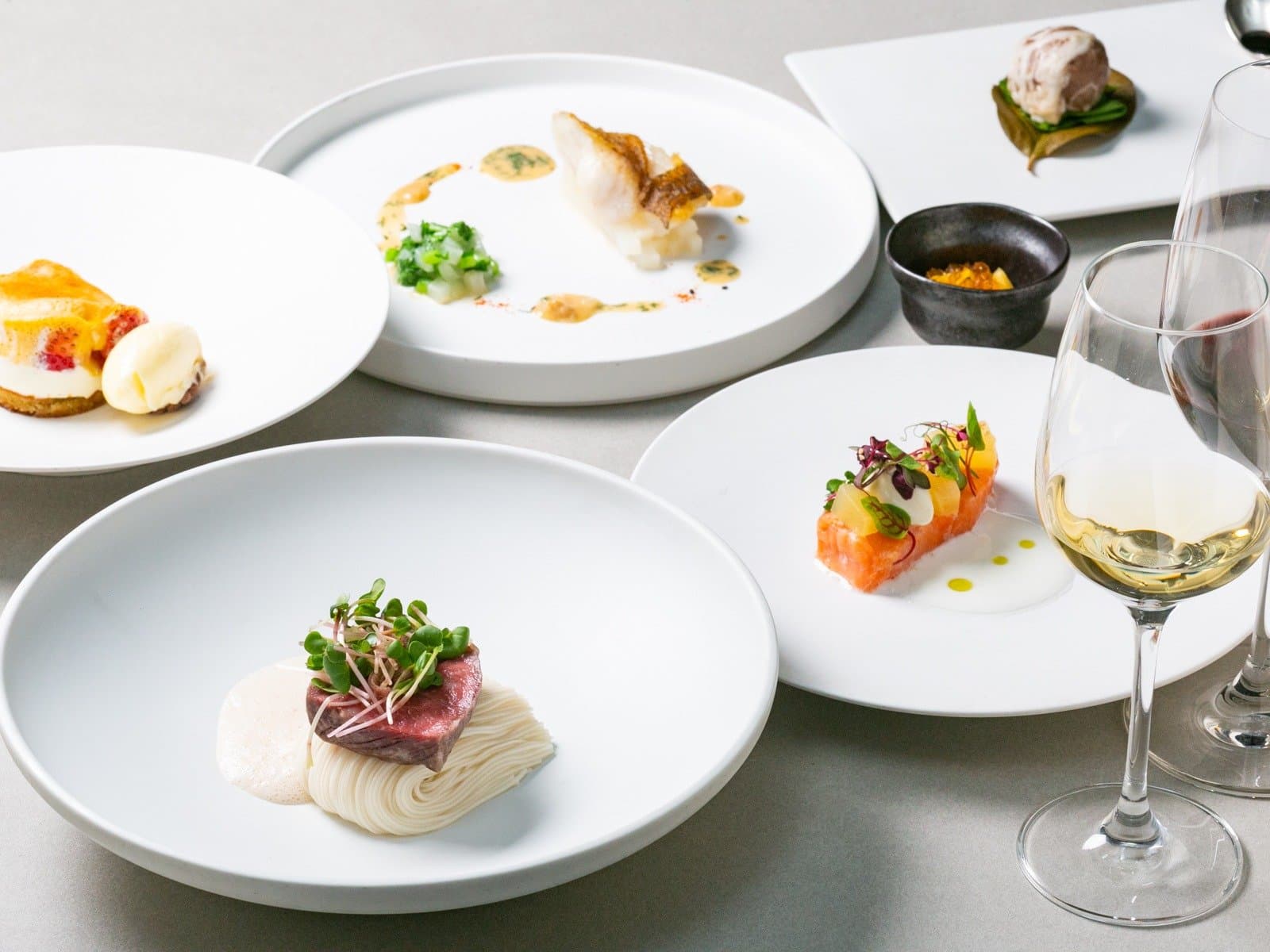 Kaiseki-style multi-course dinner spread of plated dishes with white wine at Kaze no Naramachi in Nara