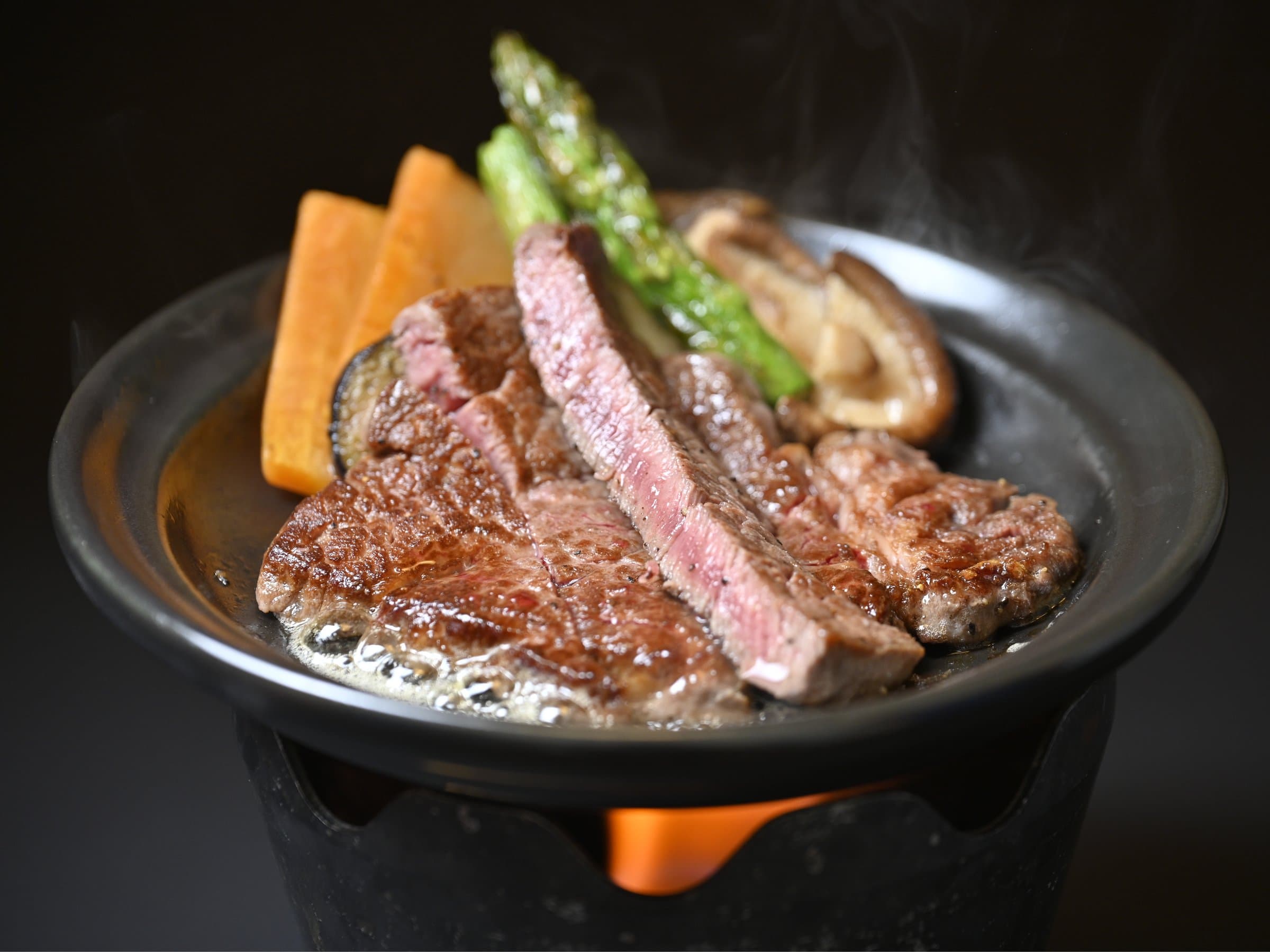 Sizzling Tochigi wagyu steak with asparagus and shiitake on a hot plate at Yumoto Itaya dinner