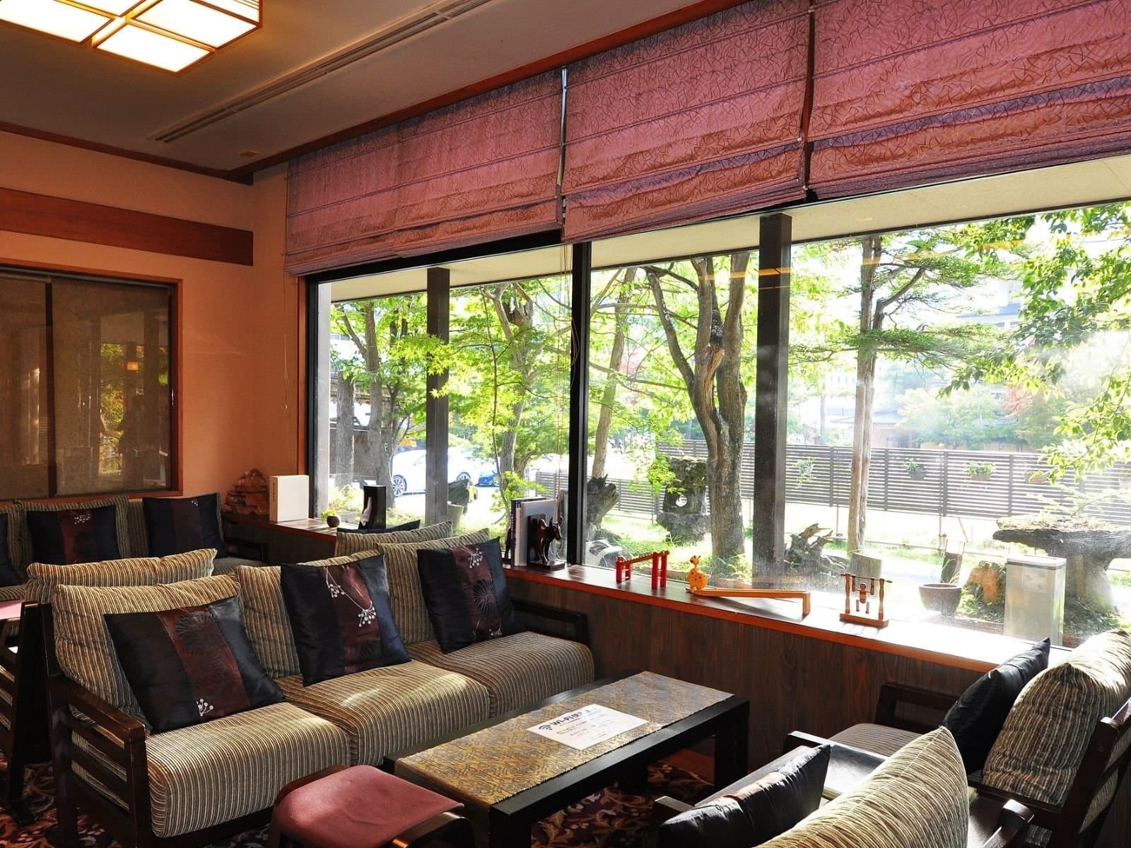Lounge with sofas and large windows facing greenery at Yumoto Itaya, Okunikko Yumoto Onsen