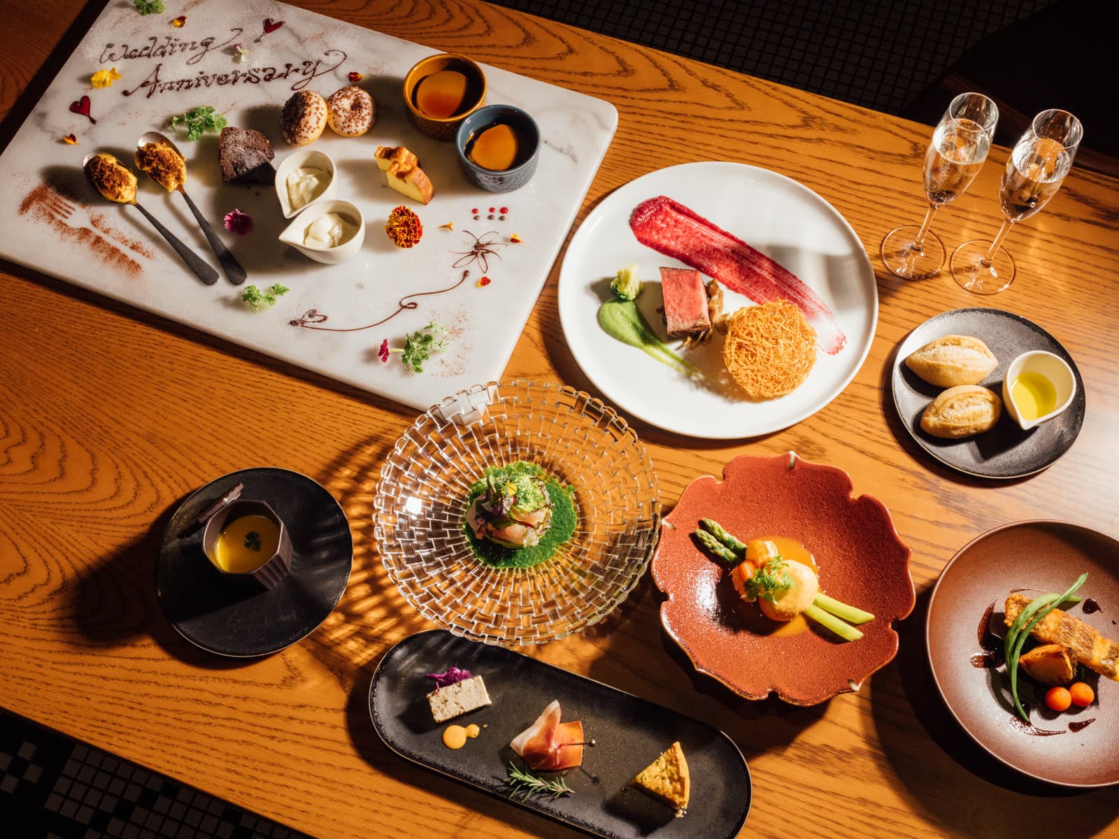 Kaiseki-style dinner course at Mercure Hida Takayama with Hida beef, assorted small plates and sparkling wine on a wood table