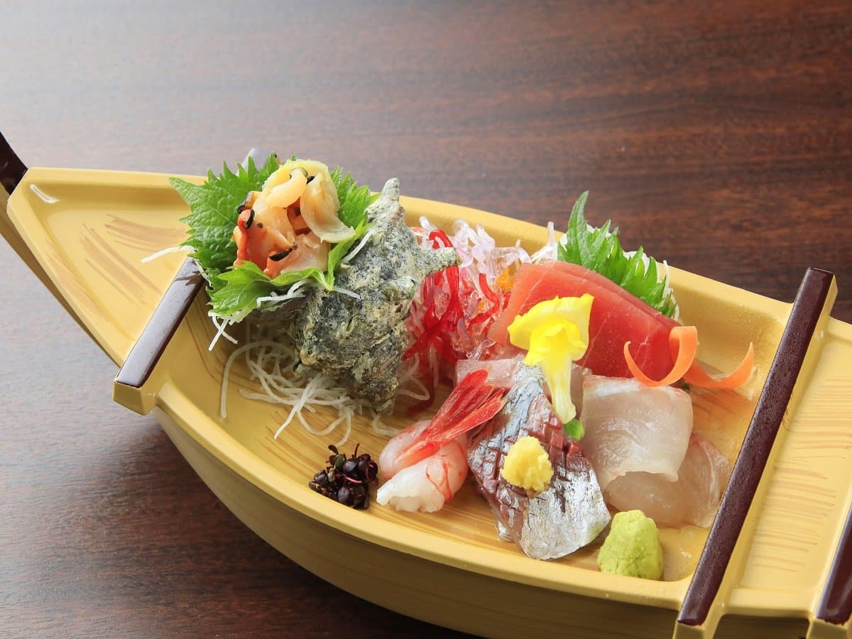 Fresh sashimi assortment served on a wooden boat platter at Hotel Dankoen, Ito Onsen, Izu