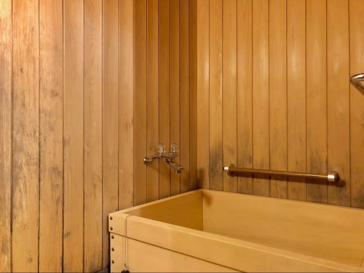 Private cypress wood bathtub and paneled bathroom in a heritage guest room at Nara Hotel