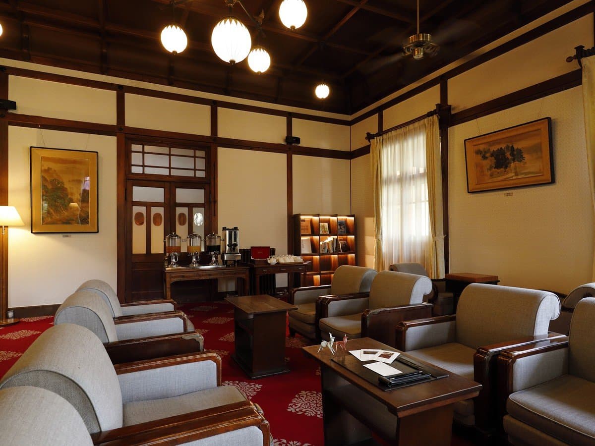 Historic lobby lounge at Nara Hotel with art deco armchairs, framed paintings and red carpet