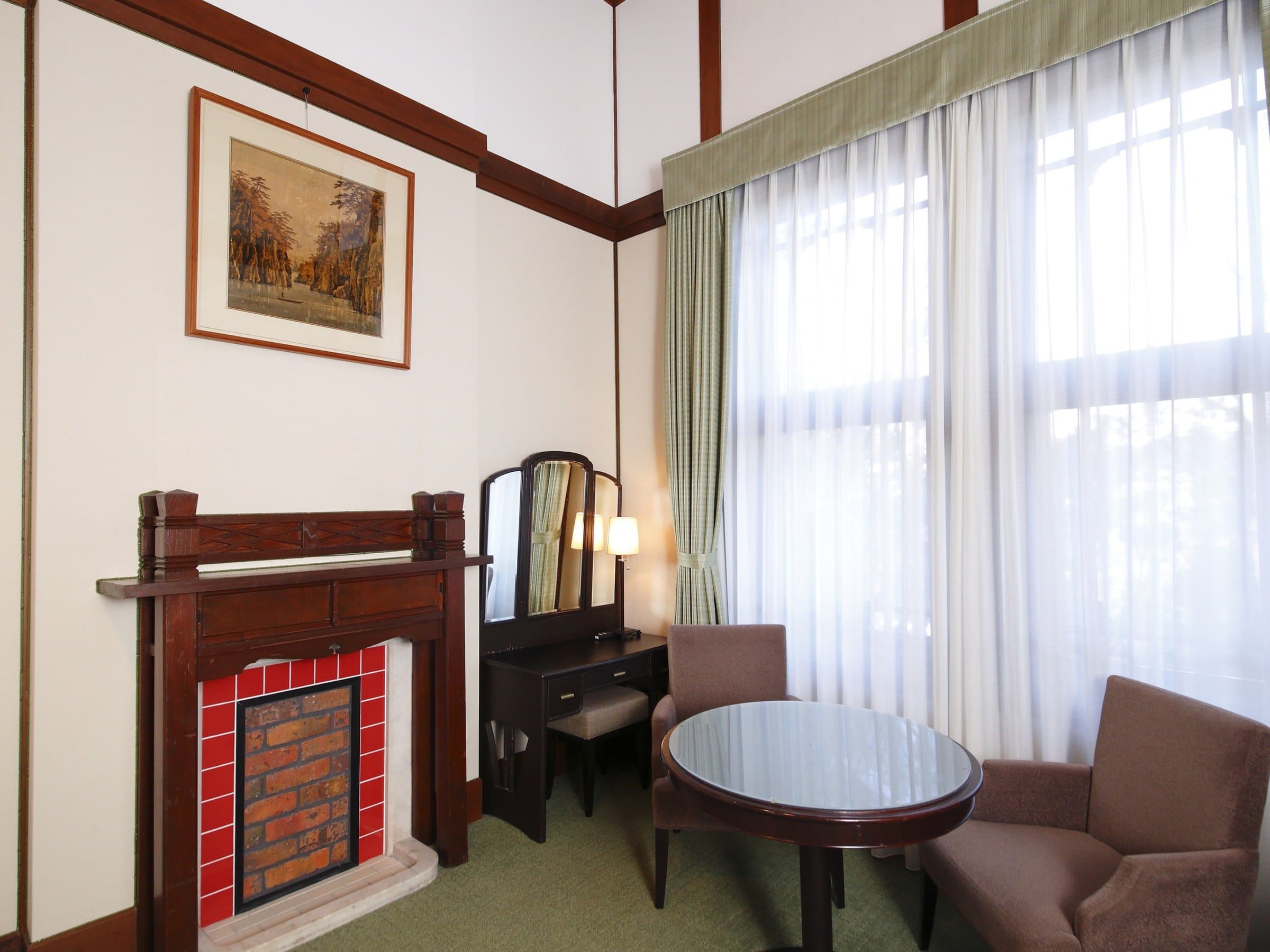 Heritage guest room at Nara Hotel with tiled fireplace, antique dressing table and bright window
