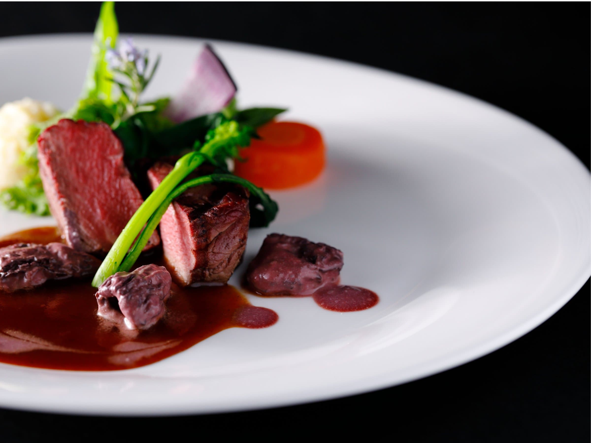 Plated venison course with cauliflower and herb garnish in red wine sauce at Nara Hotel dining