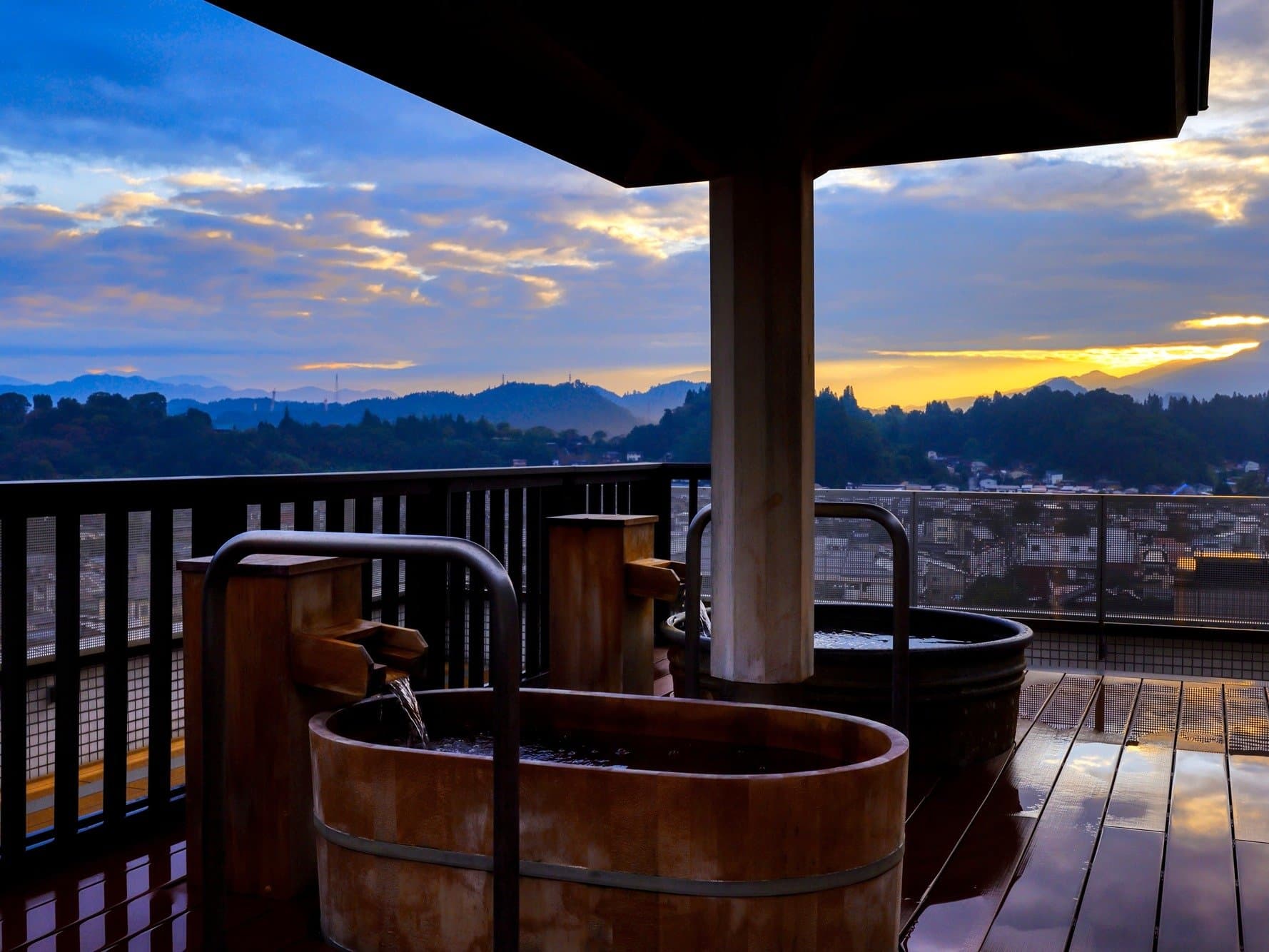 Rooftop wooden barrel open-air baths at Hida Hotel Plaza overlooking Takayama town at sunset