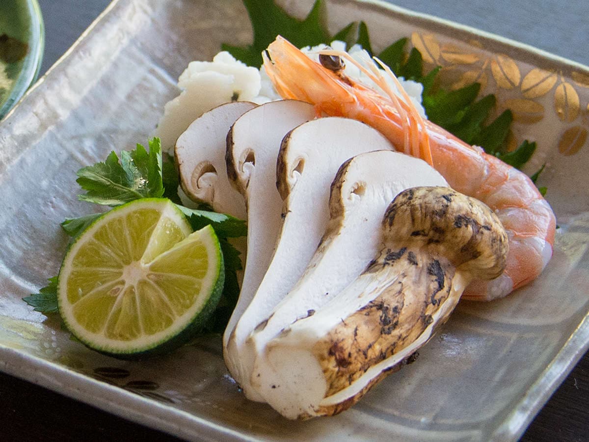 Seasonal kaiseki course of sliced matsutake mushroom and sweet prawn with sudachi citrus on a ceramic plate at Motoyu Ryusenkaku, Arima Onsen