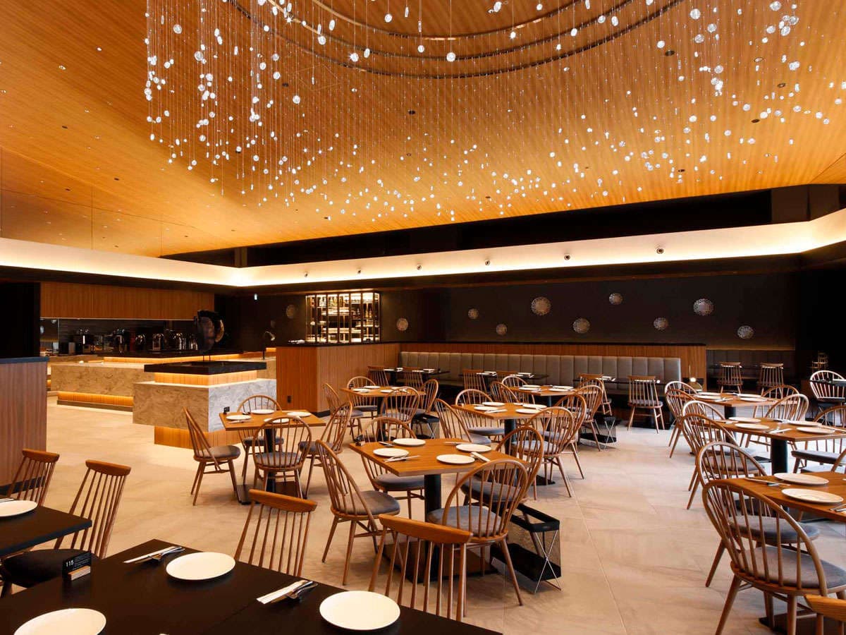 Elegant dining hall at Takayama Green Hotel with wooden chairs and a cascading crystal light installation