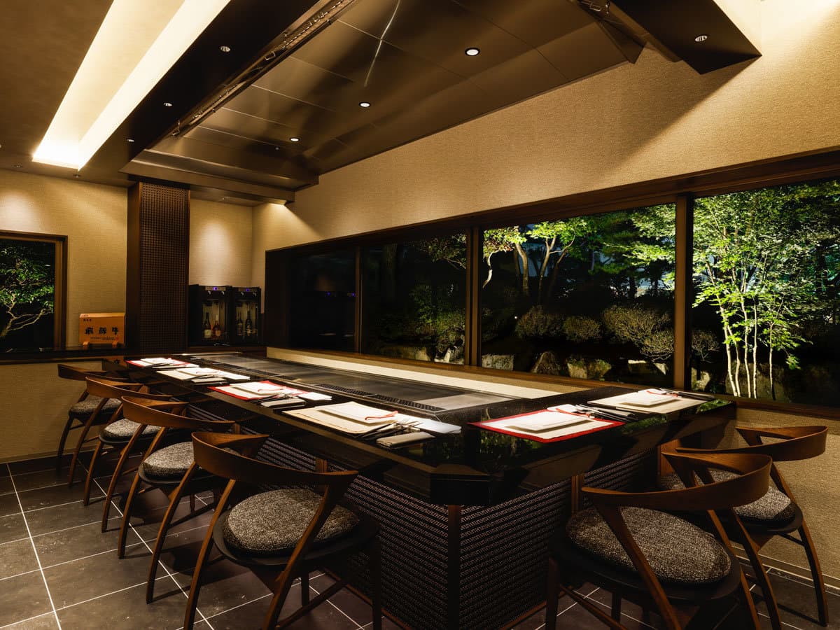 Teppanyaki counter restaurant at Takayama Green Hotel overlooking an illuminated evening garden