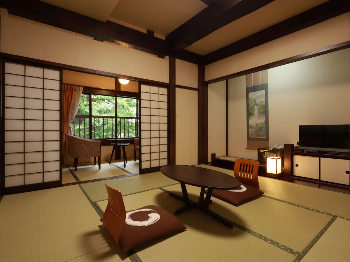 Traditional tatami guest room at Ryokan Murayama with hanging scroll, low table and shoji screens