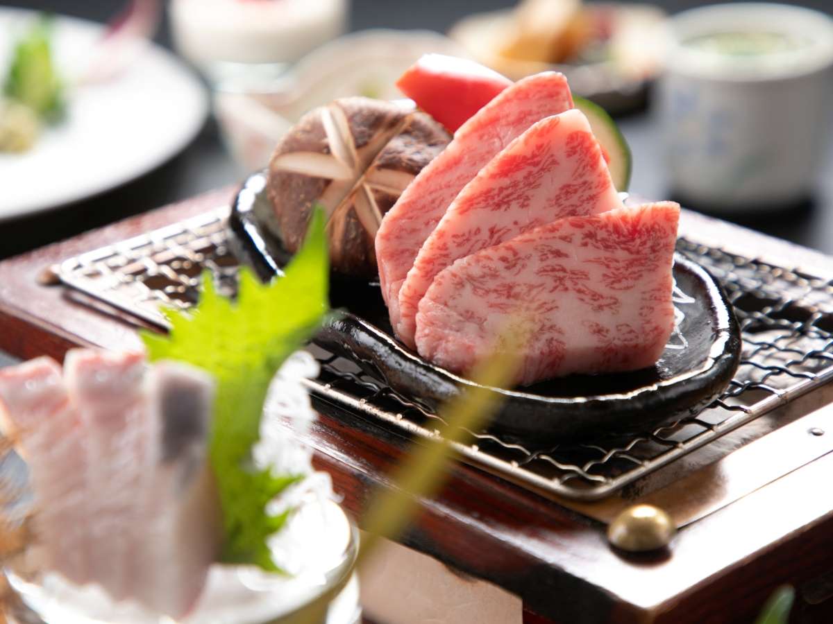 Marbled wagyu beef grilled on a tabletop charcoal stone in a kaiseki dinner at Yufuin Hoteiya