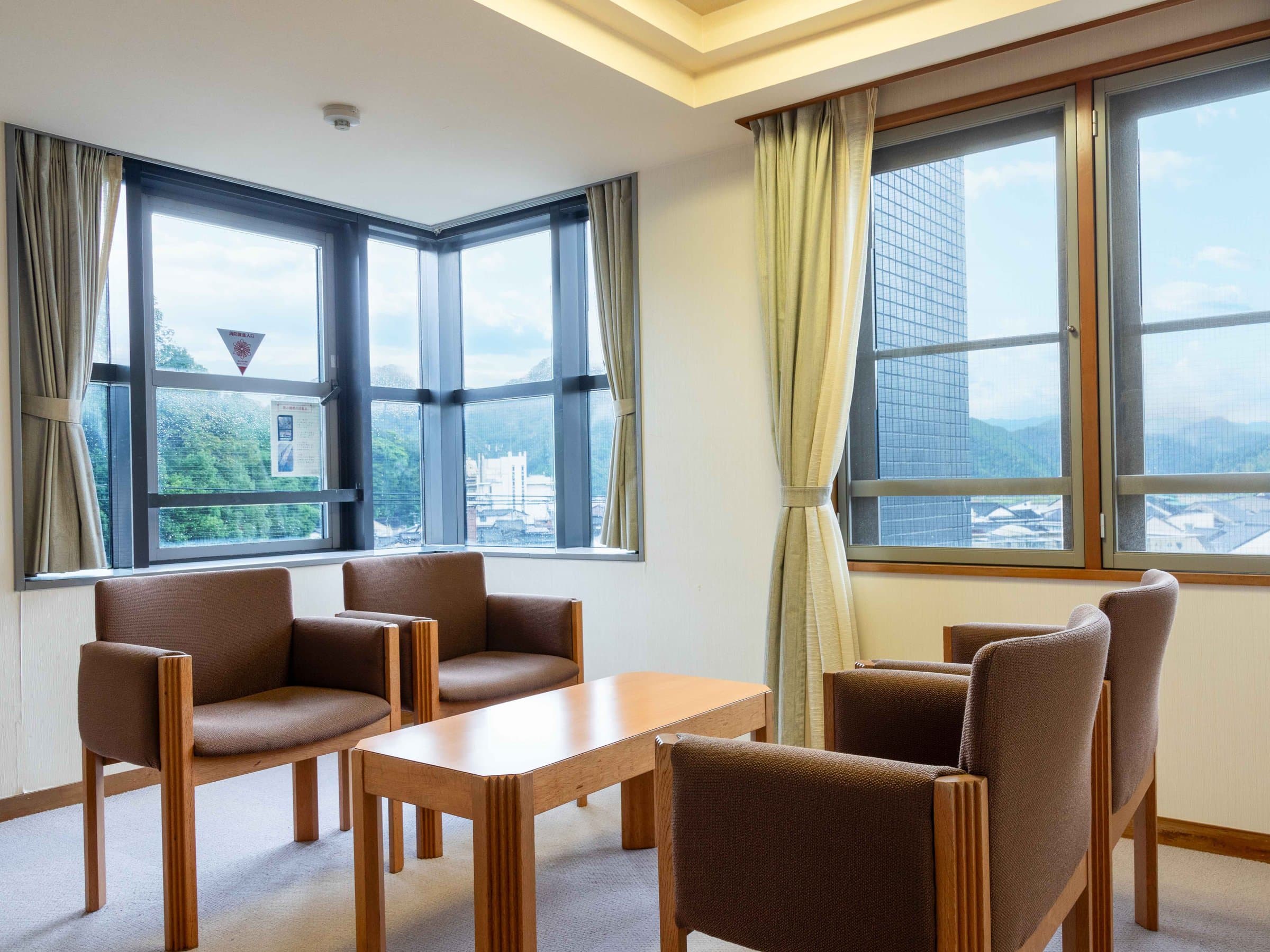 Suizanso Kinosaki Onsen guest room sitting area with table, chairs and outdoor view