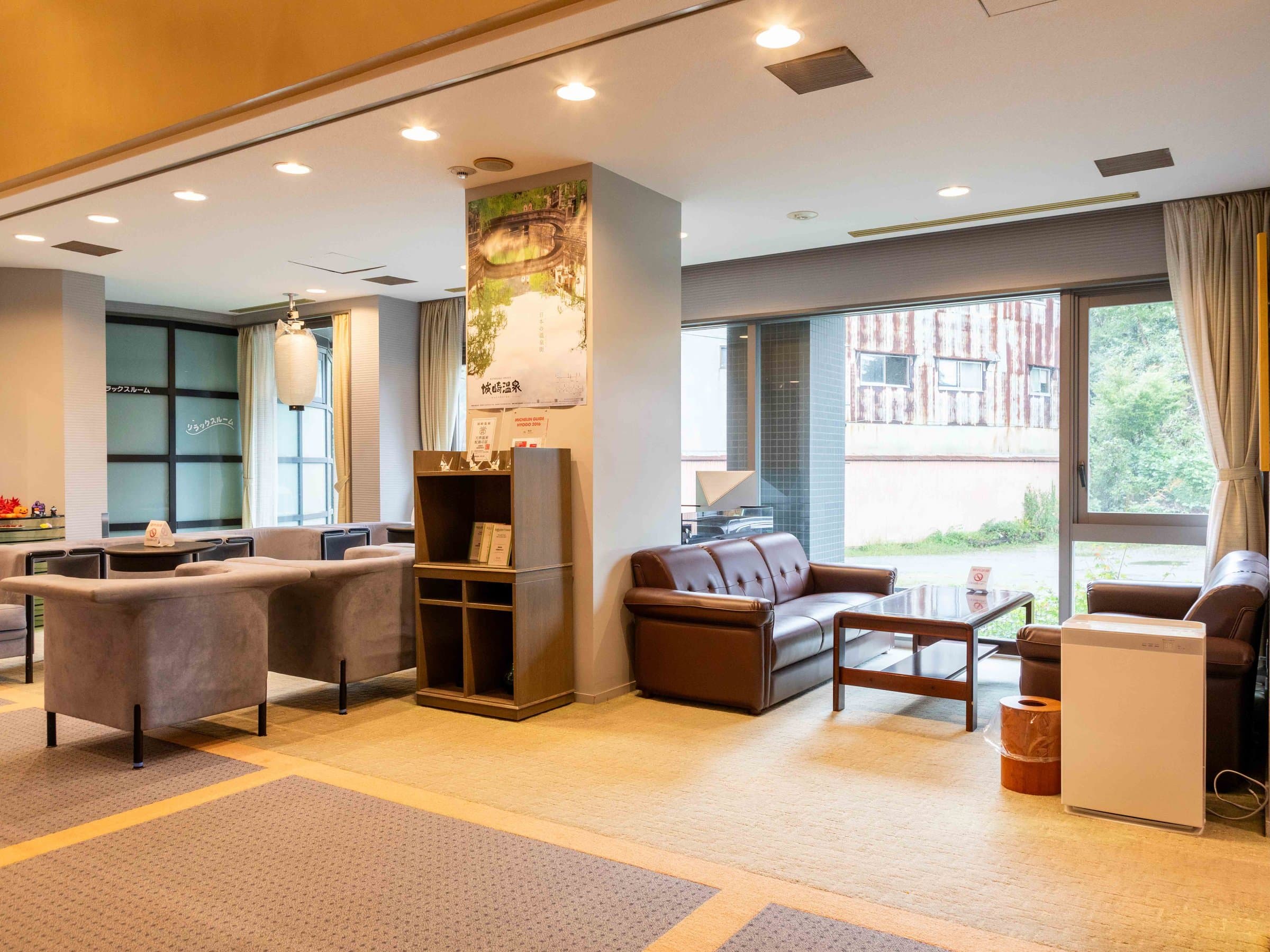 Suizanso Kinosaki Onsen lounge seating area with large windows overlooking the grounds