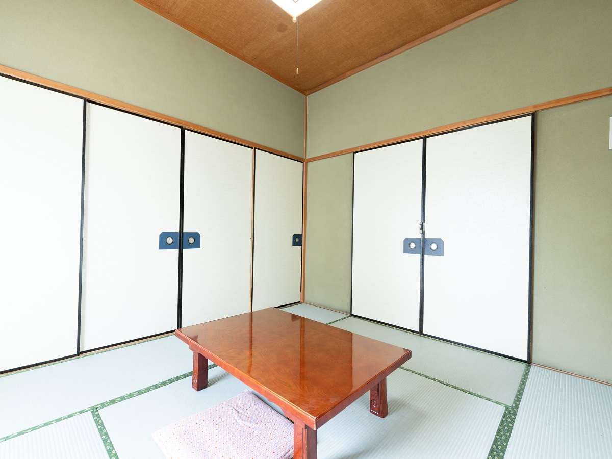 Traditional tatami guest room at Sakura Ryokan with sliding closet doors and a lacquered low table