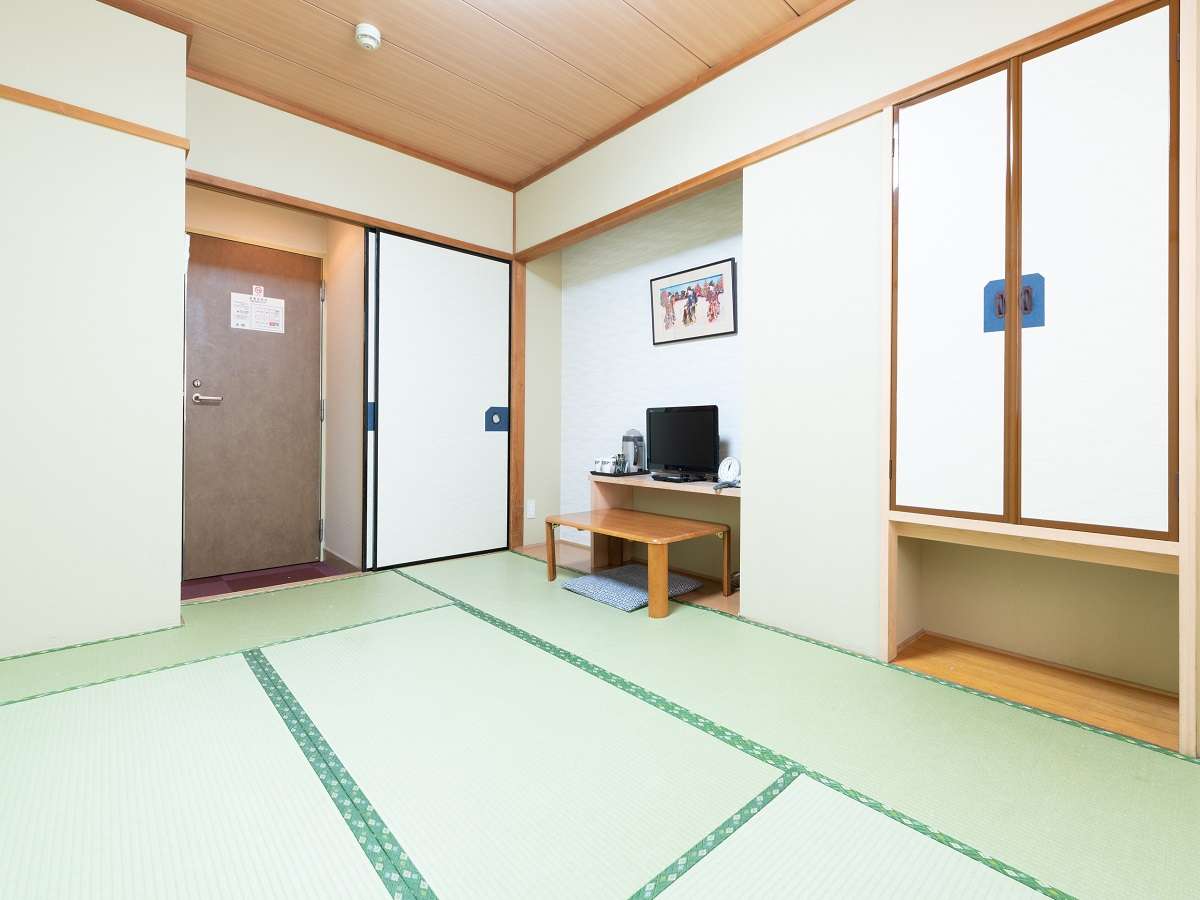 Tatami guest room at Sakura Ryokan with entrance vestibule, alcove desk and television