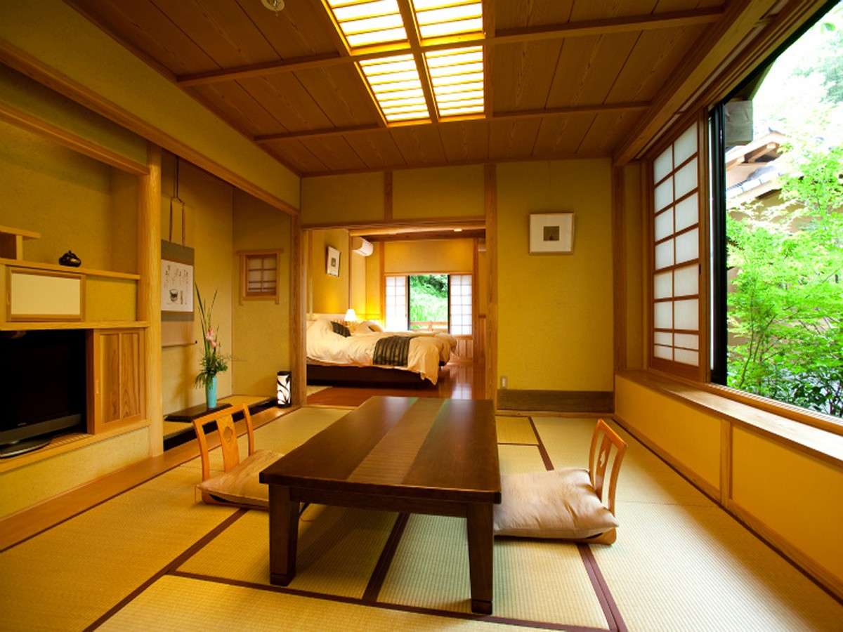 Tatami guest room at Oyado Nonohana with low table and a wide window overlooking the garden