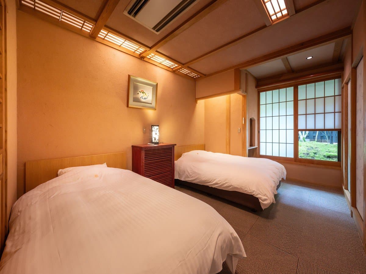 Japanese-Western guest room at Oyado Nonohana with twin beds and a garden-view window
