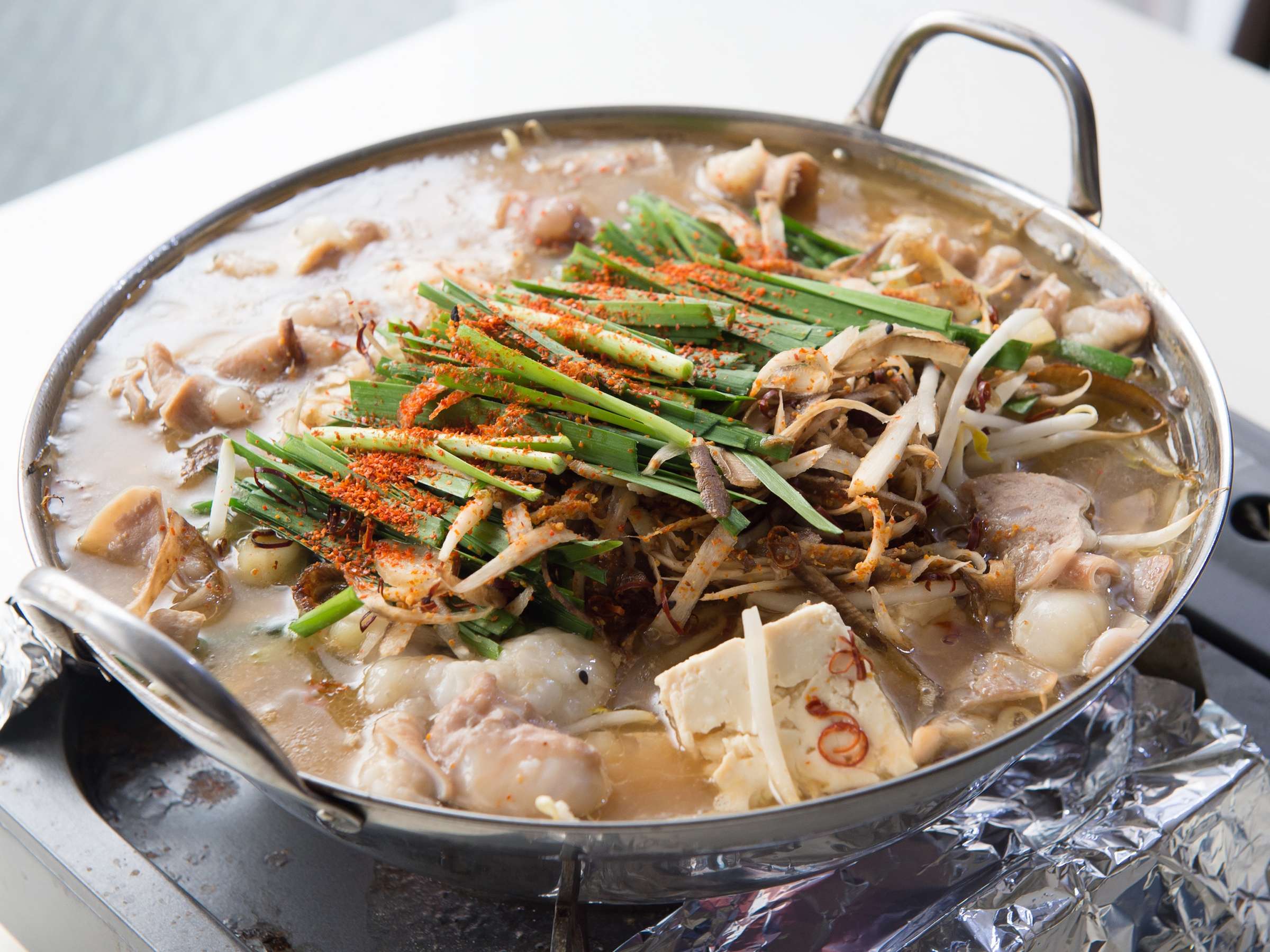 Bubbling Hakata-style motsunabe offal hot pot with leek, garlic chives and tofu served at Yamamoto Ryokan