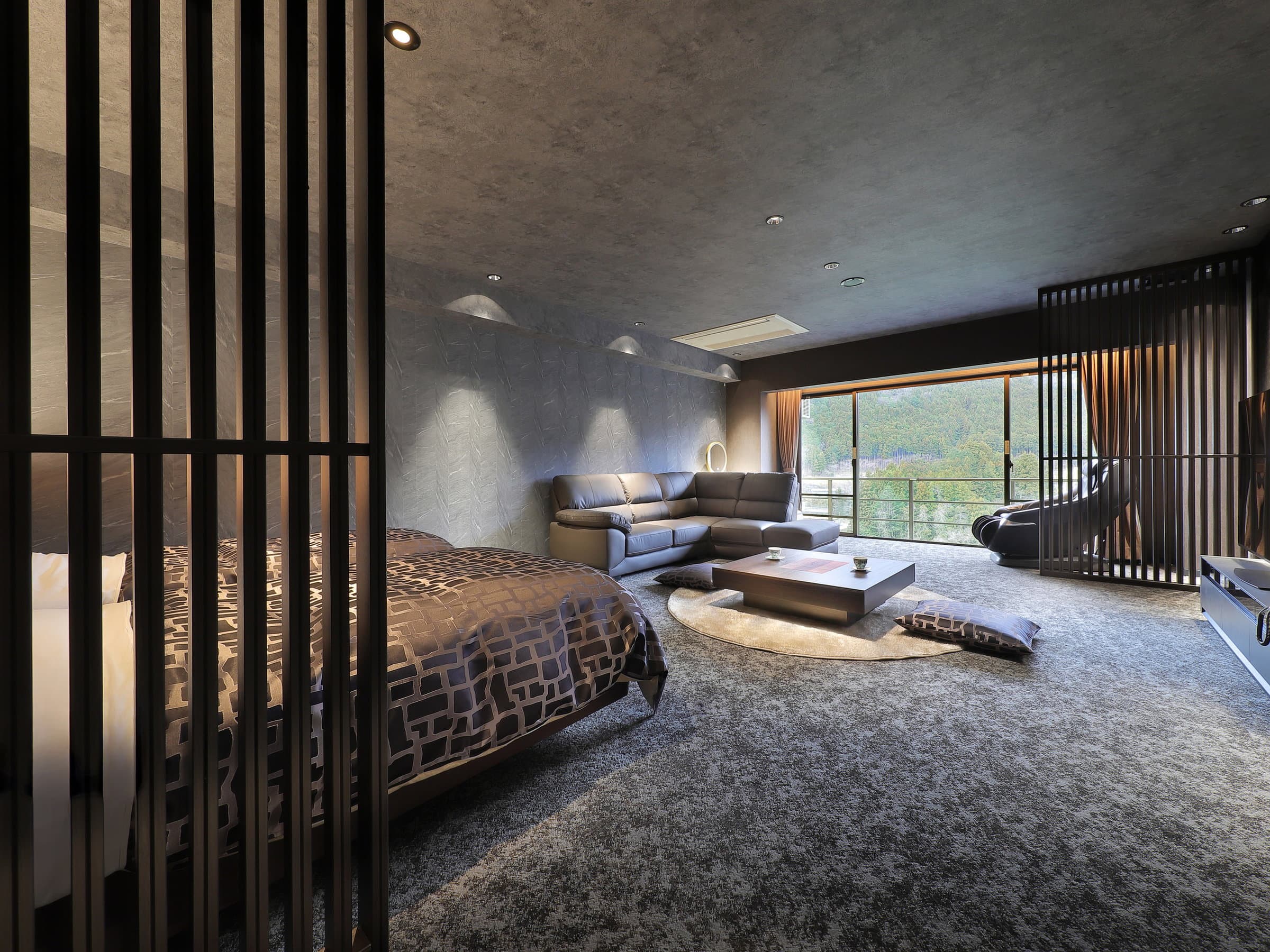 Spacious modern premium guest room with low bed, sofa lounge and mountain-view window at Wakatake no Sho, Kinugawa Onsen