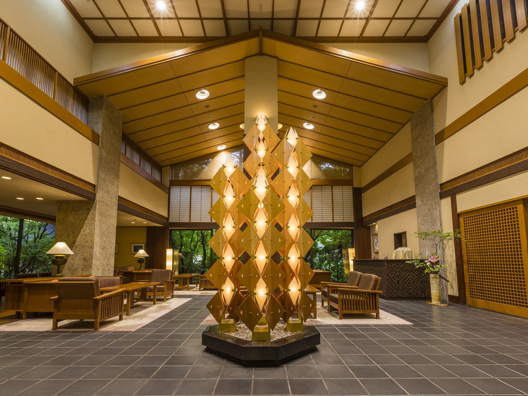 Grand high-ceilinged lobby with golden diamond-lattice sculpture and wooden lounge seating at Wakatake no Sho, Kinugawa Onsen