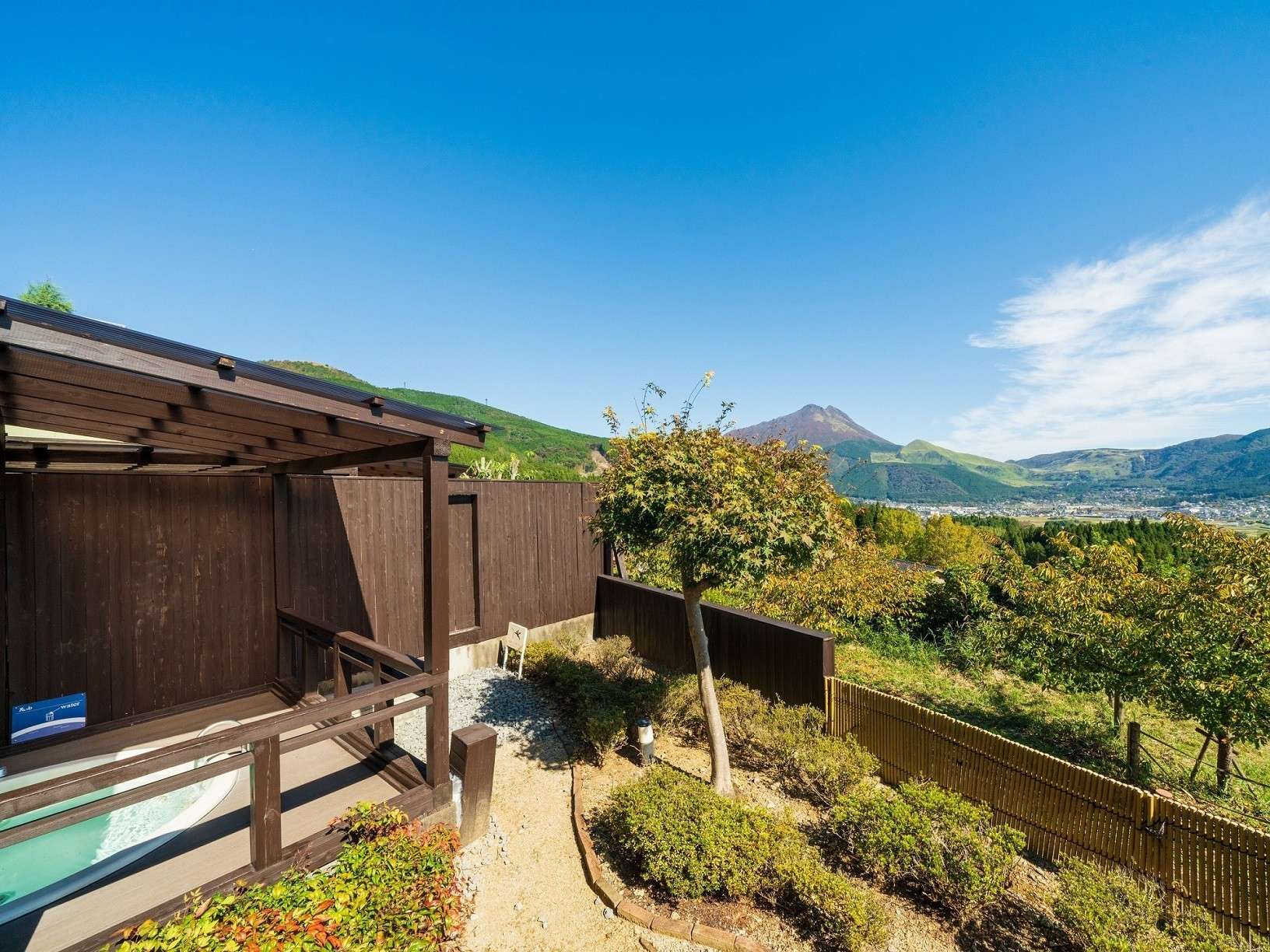 Open-air bath terrace at Yufuin Hanayoshi overlooking the Yufuin valley and surrounding mountains