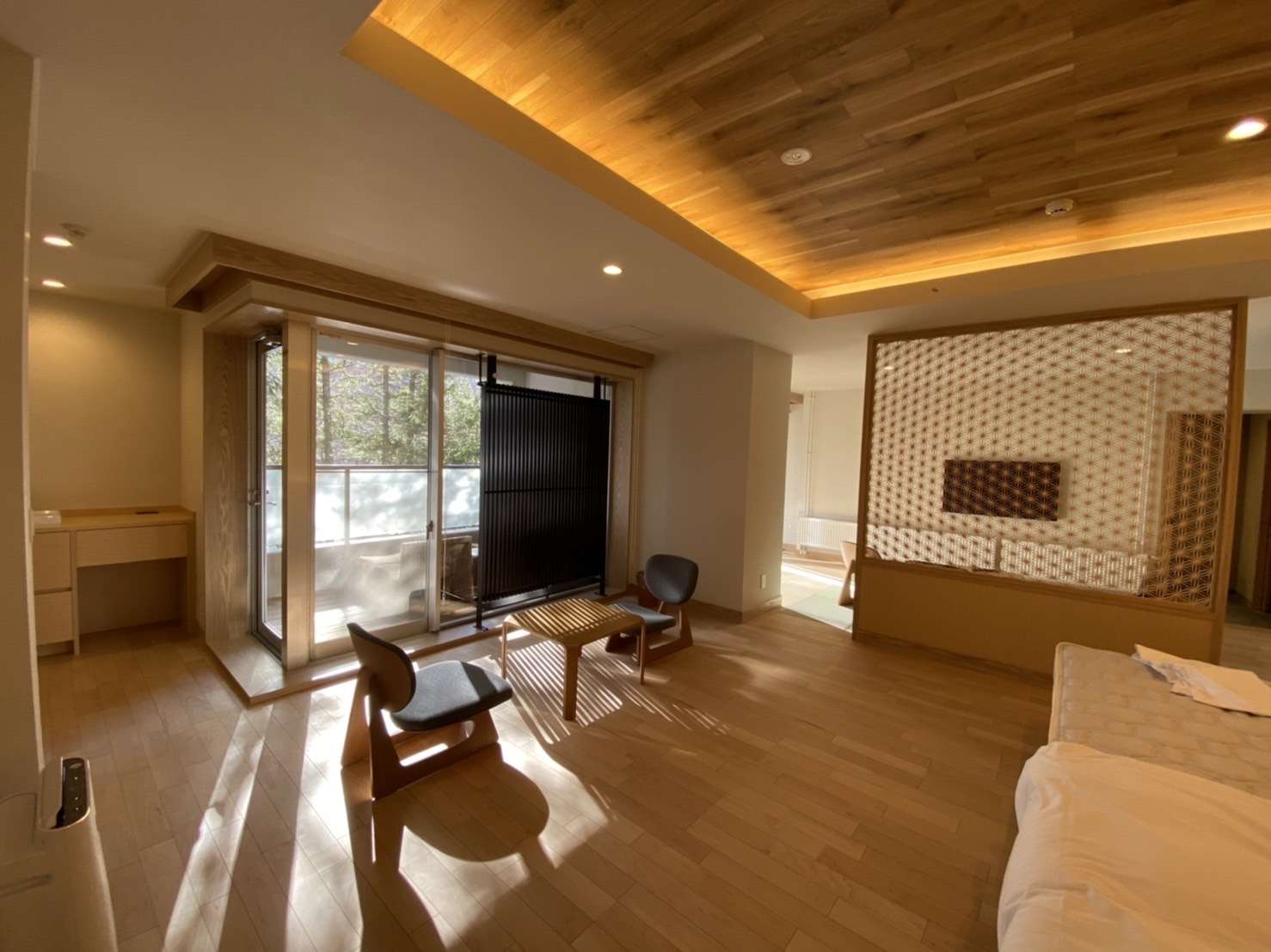 Bright suite living area with low lounge chairs and a forest-facing terrace at Okunikko Yuno-mori