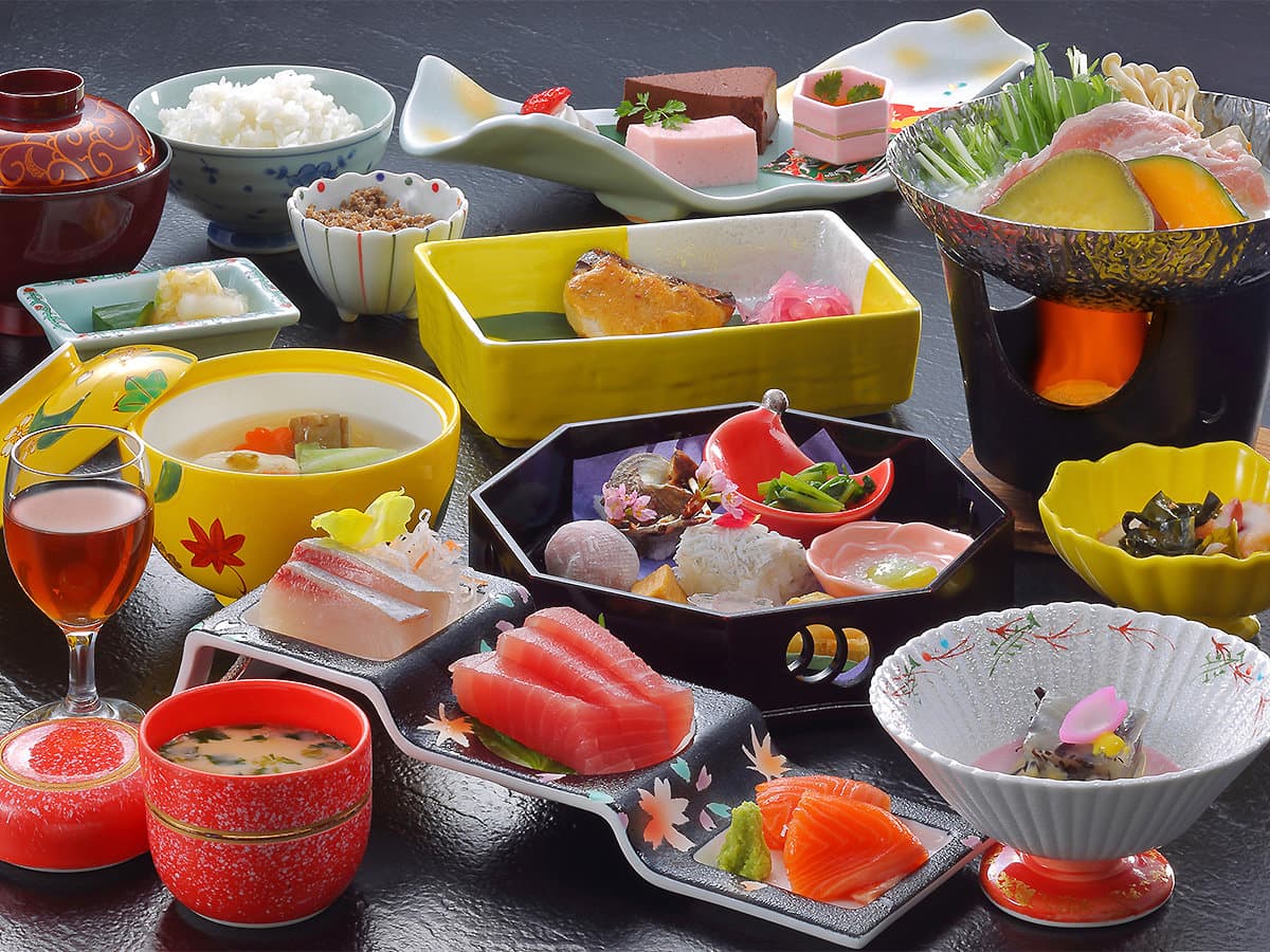 Multi-course Japanese kaiseki dinner with sashimi, hot pot, simmered dishes and rice laid out at Hotel Sunshine Kinugawa
