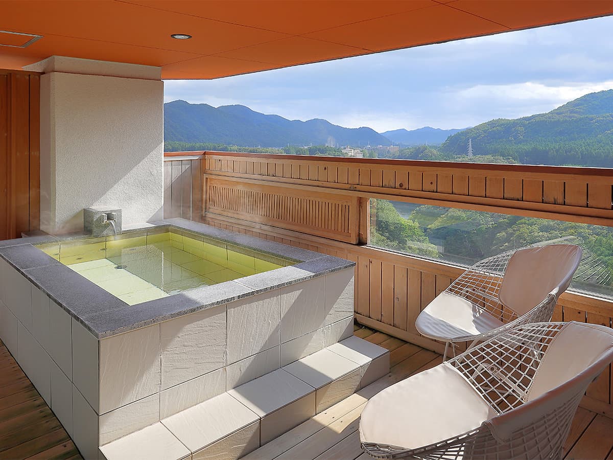 Private open-air balcony bath with chairs and panoramic mountain view at Hotel Sunshine Kinugawa, Kinugawa Onsen