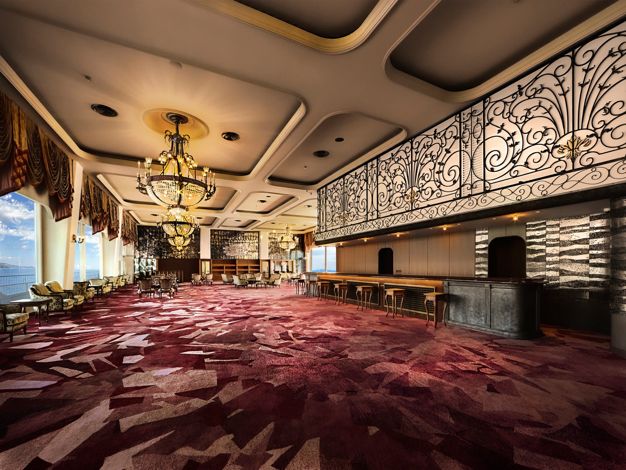 Grand lobby lounge with chandeliers, patterned carpet and ocean windows at Hotel New Akao, Atami
