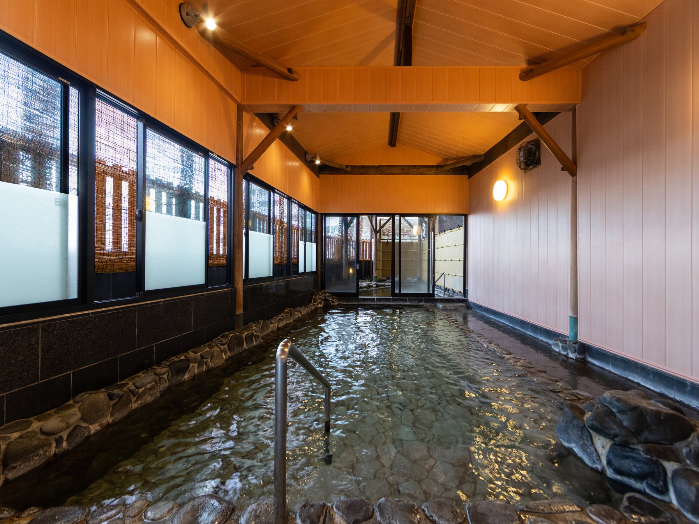 Indoor stone hot-spring bath with timber ceiling at Hotel New Akao, Atami Onsen