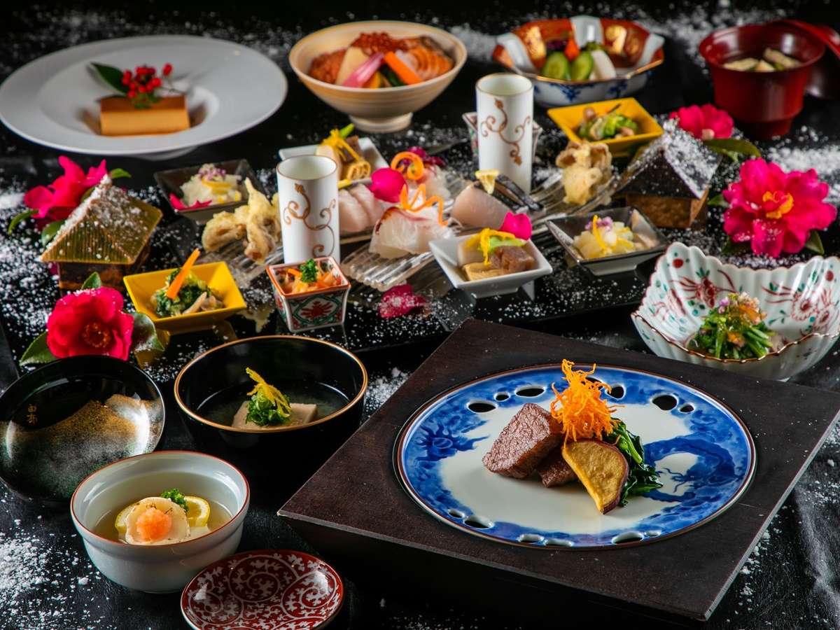 Multi-course kaiseki dinner spread with grilled beef and camellia garnish at Yufuin Bettei Itsuki