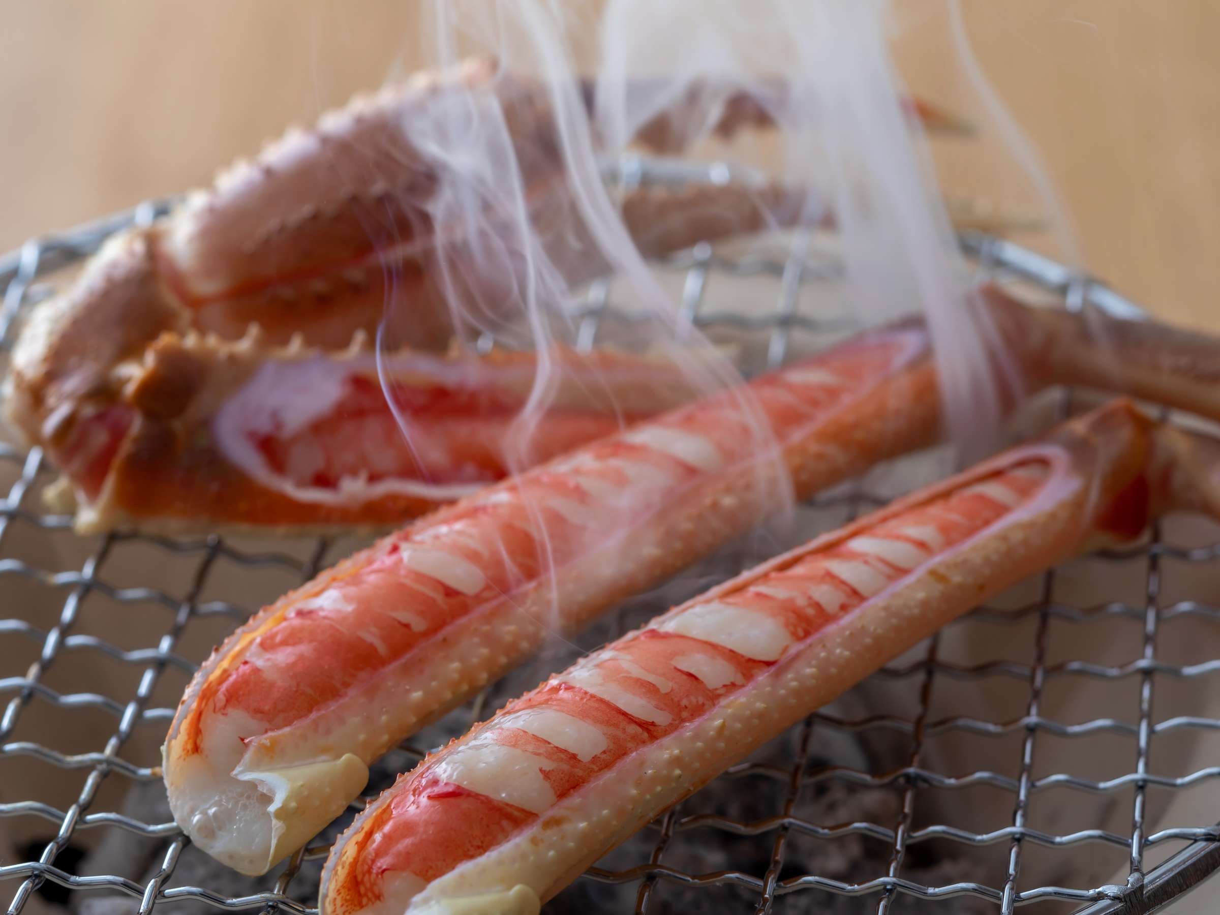 Grilled snow crab legs steaming over a charcoal mesh grill, Sensui, Kinosaki Onsen