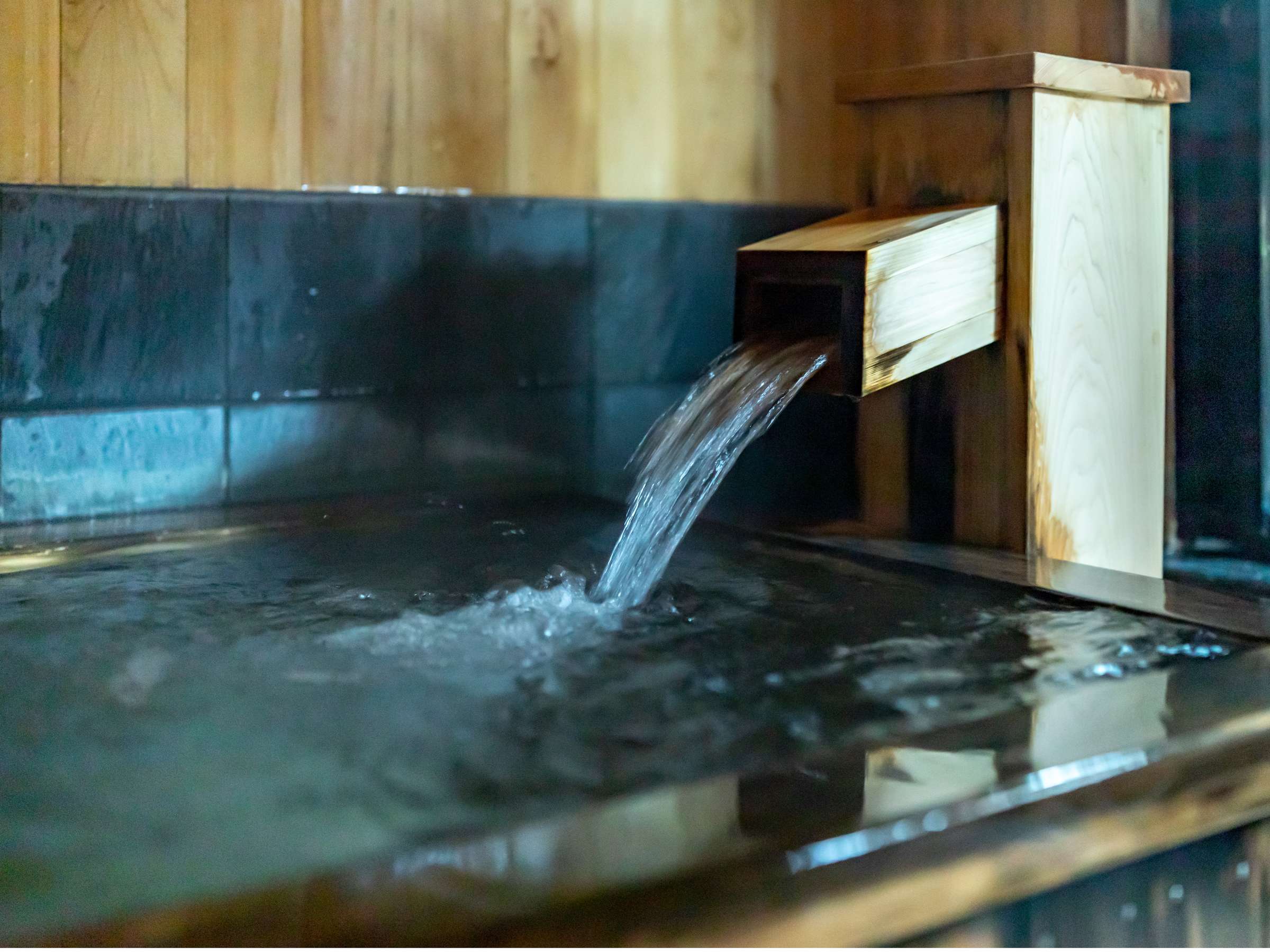 Wood-clad private onsen tub fed by a flowing wooden water chute, Sensui, Kinosaki Onsen