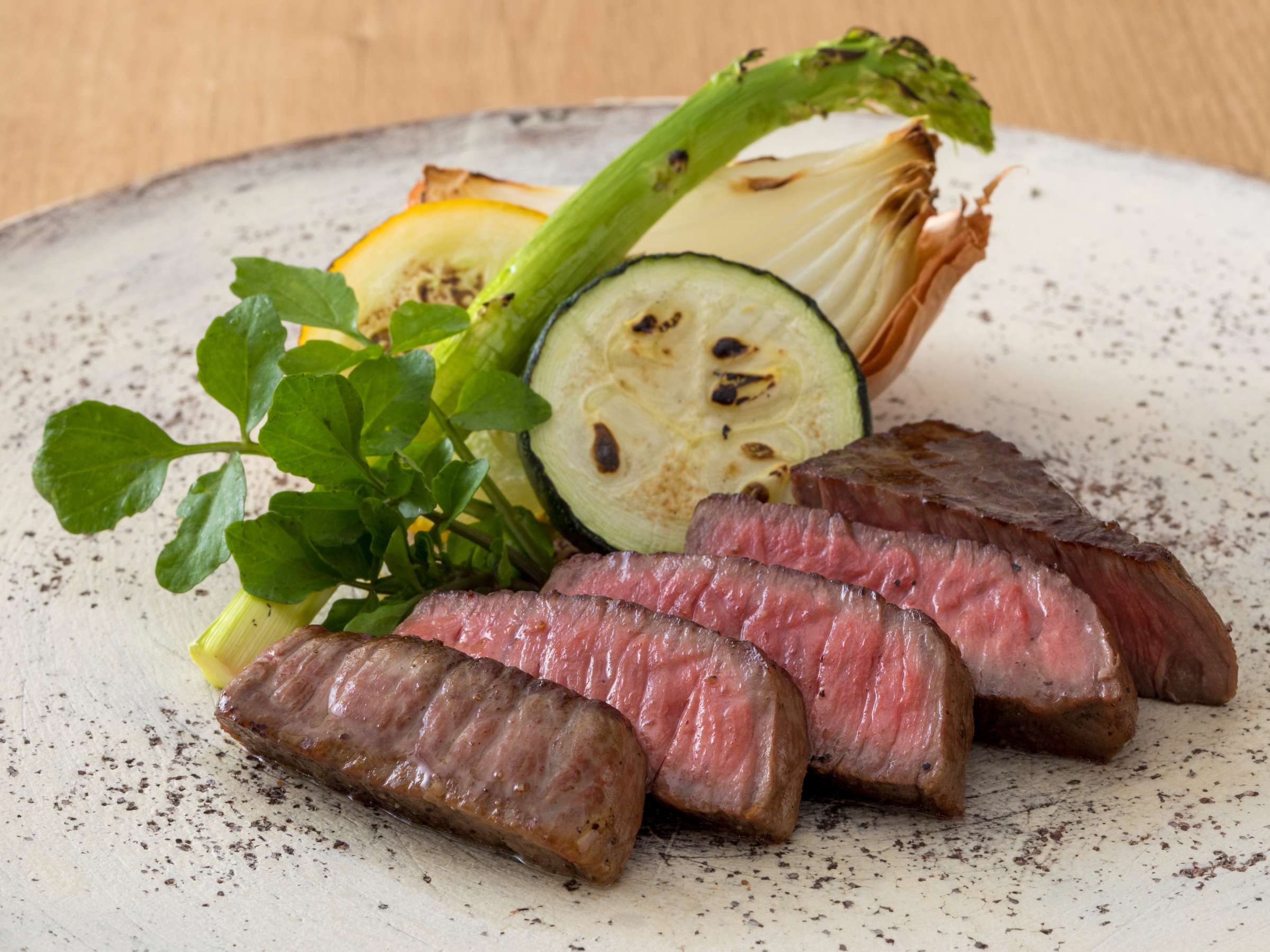 Sliced seared Tajima beef steak with grilled seasonal vegetables on a stone plate, Sensui, Kinosaki Onsen