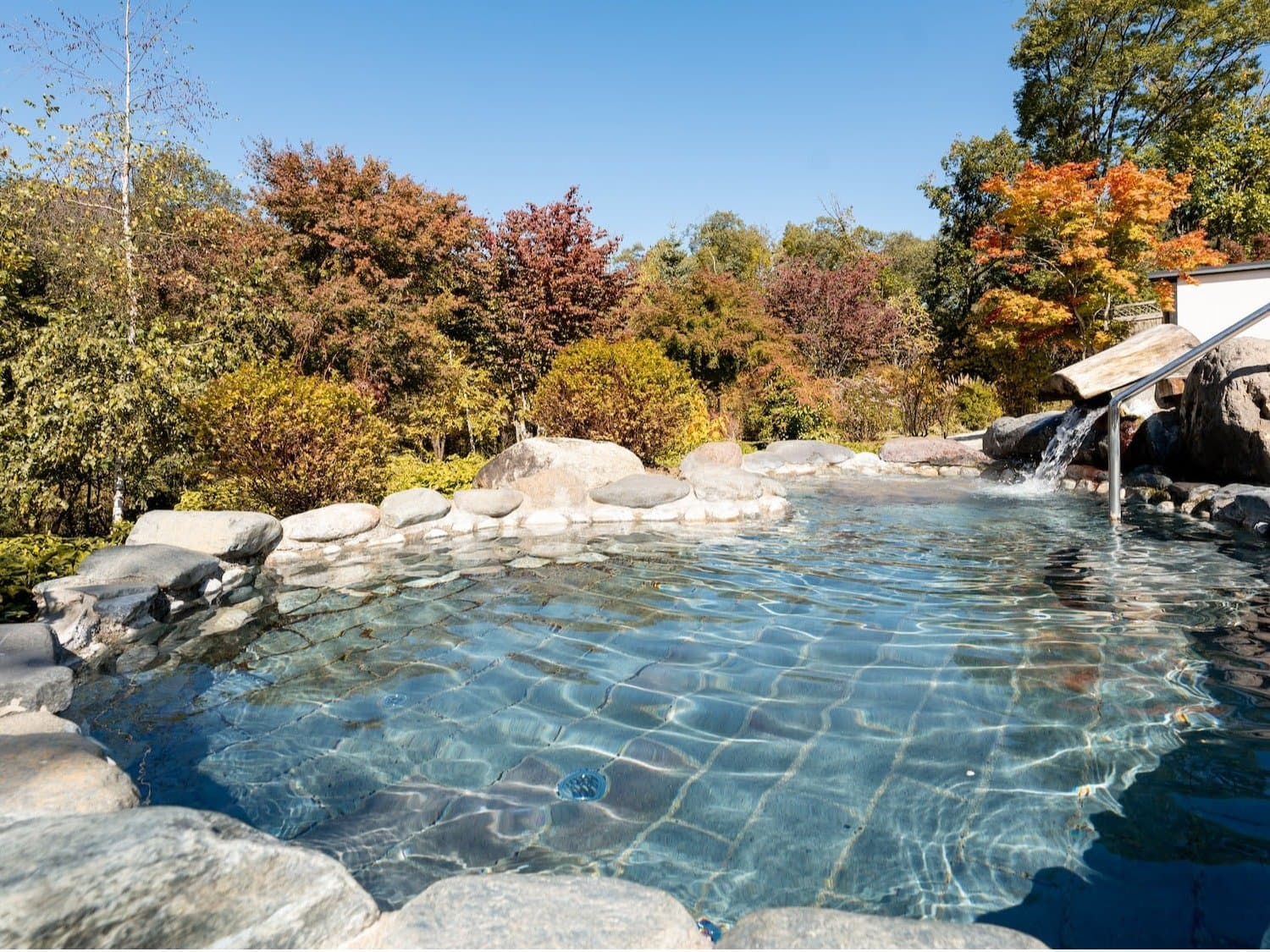 Outdoor rotenburo hot-spring bath ringed by autumn foliage at Hotel Sierra Resort Hakuba, Mizubasho Onsen
