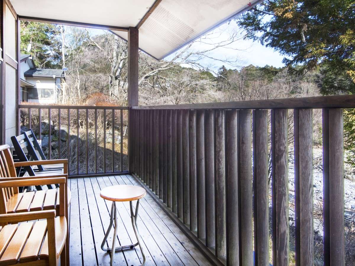 Private wooden veranda balcony at Nikko Tokanso with chairs facing the surrounding Nikko mountain woodland
