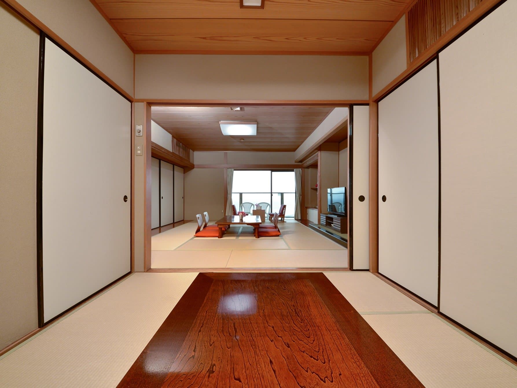 Deluxe two-room Japanese suite with tatami sitting area and ocean-facing windows at Hotel Katara, Atagawa Onsen