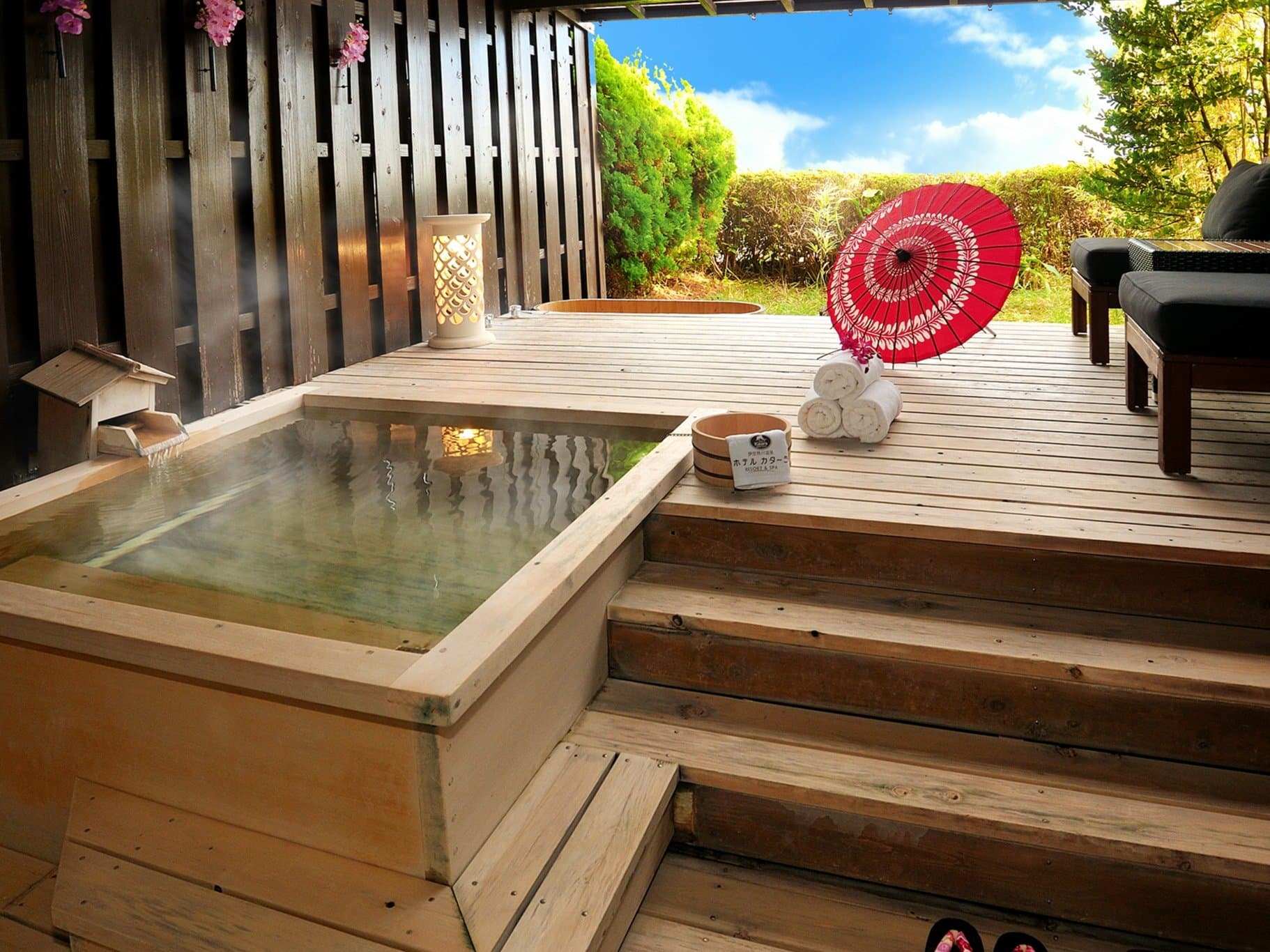 Private cypress open-air tub on a sunlit wooden deck with a red wagasa parasol, Hotel Katara, Atagawa Onsen