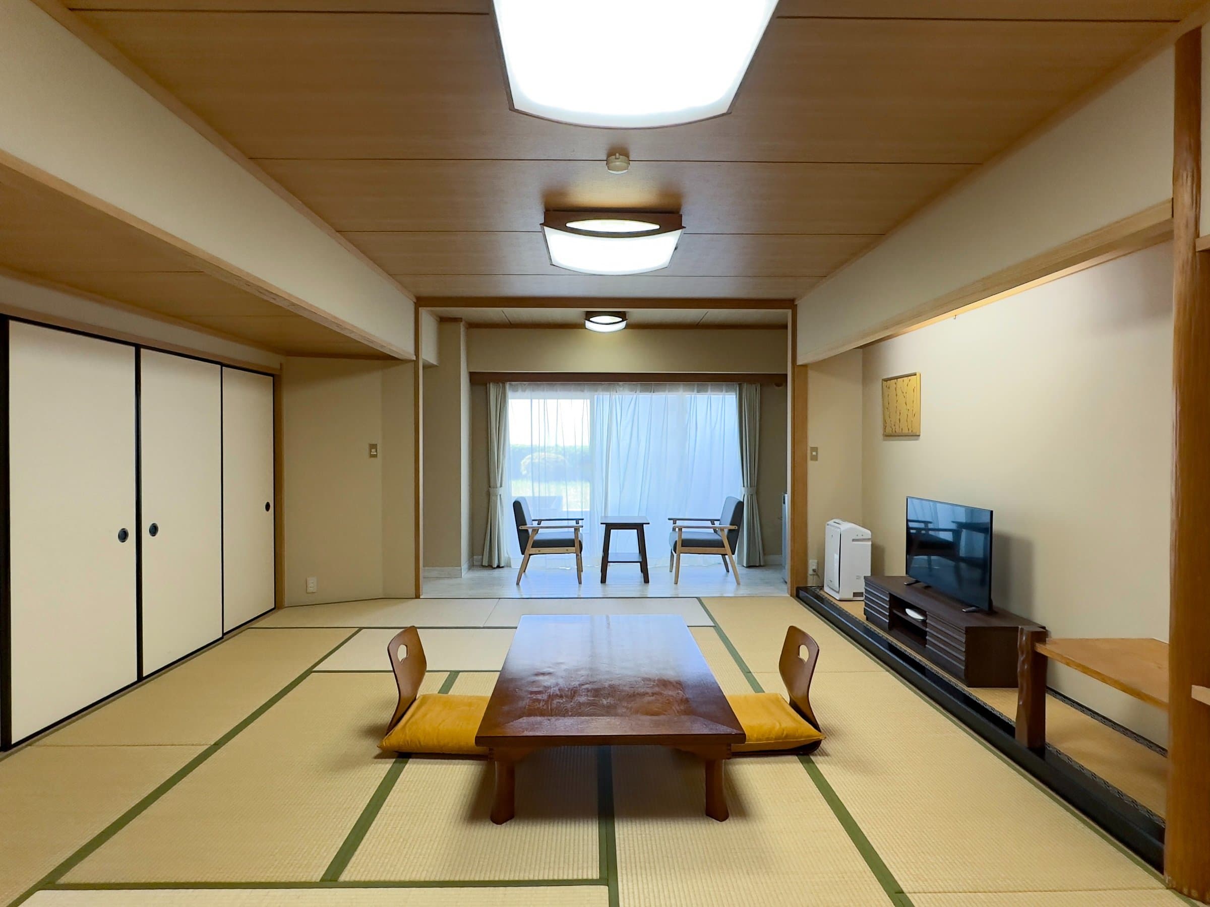 Standard tatami guest room with chabudai table and balcony seating overlooking the Izu coast, Hotel Katara