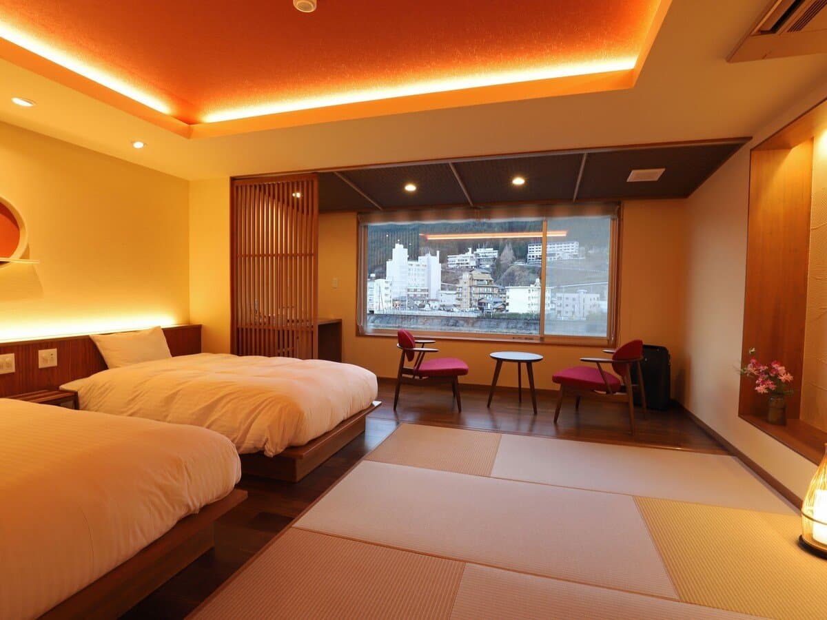Modern twin-bed Japanese room with tatami and a large window over the onsen town, Yamagataya, Gero Onsen