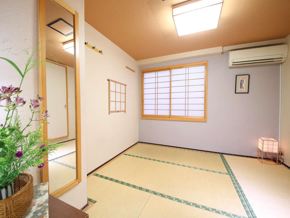 Clean Japanese-style tatami guest room at Ryokan Kamogawa Asakusa with shoji window, standing mirror and seasonal flowers