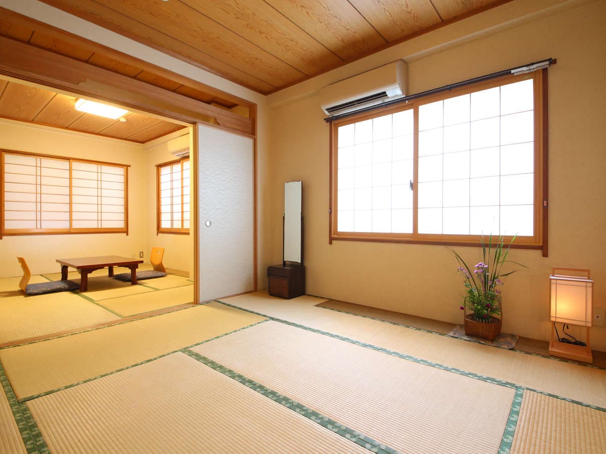 Connected two-room tatami suite at Ryokan Kamogawa Asakusa with shoji screens, ikebana arrangement and andon lamp
