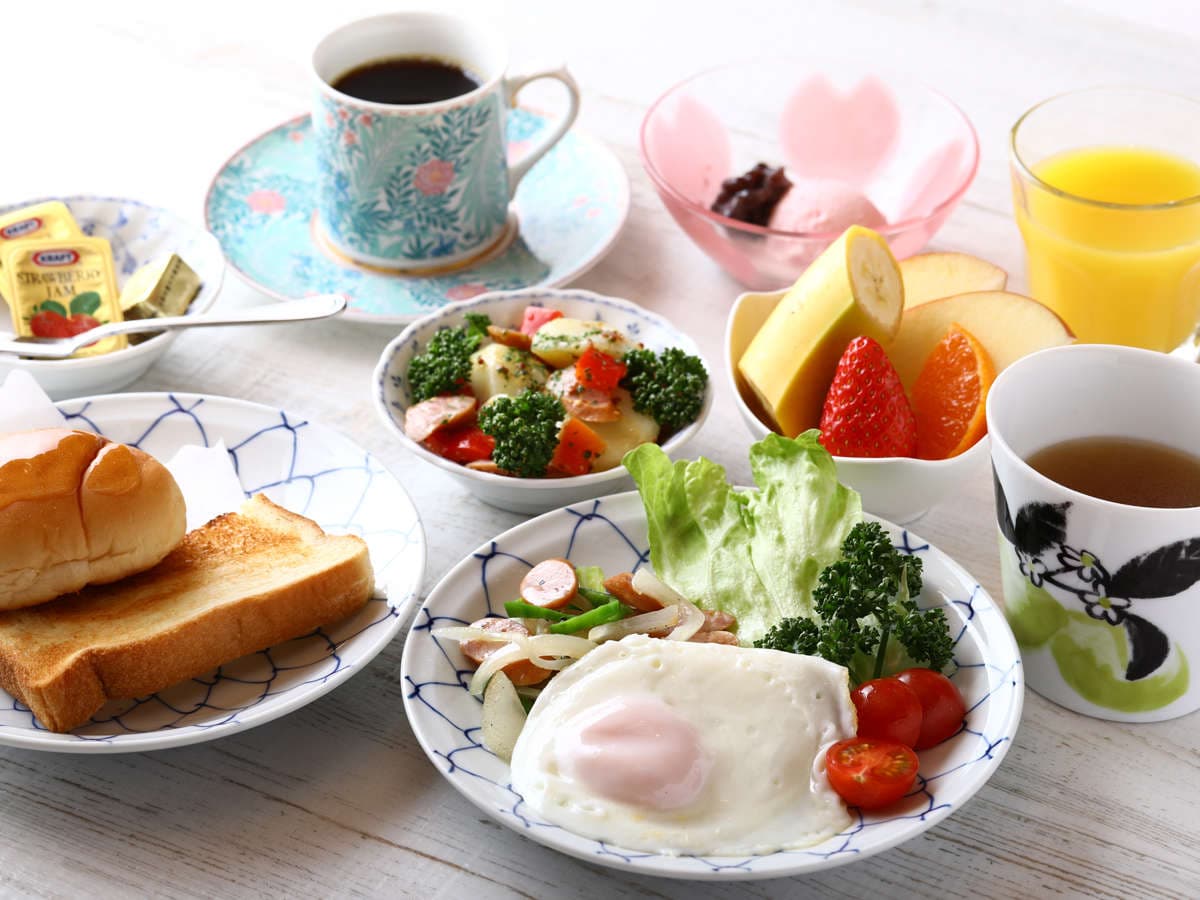 Western breakfast set at Ryokan Kamogawa Asakusa with toast, fried egg, sausage salad, fruit and coffee