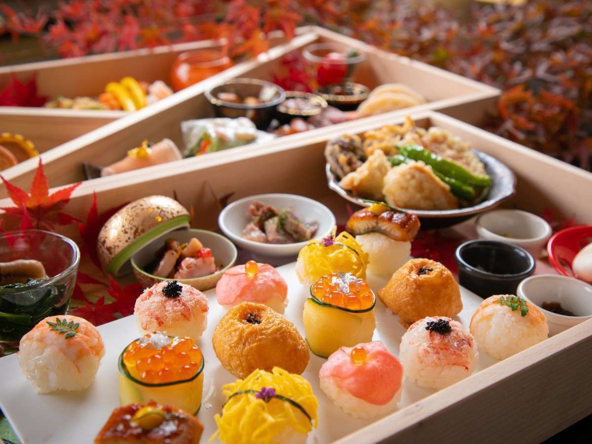 Autumn temari-zushi and tempura course served in wooden boxes amid red maple leaves at Tosyoan